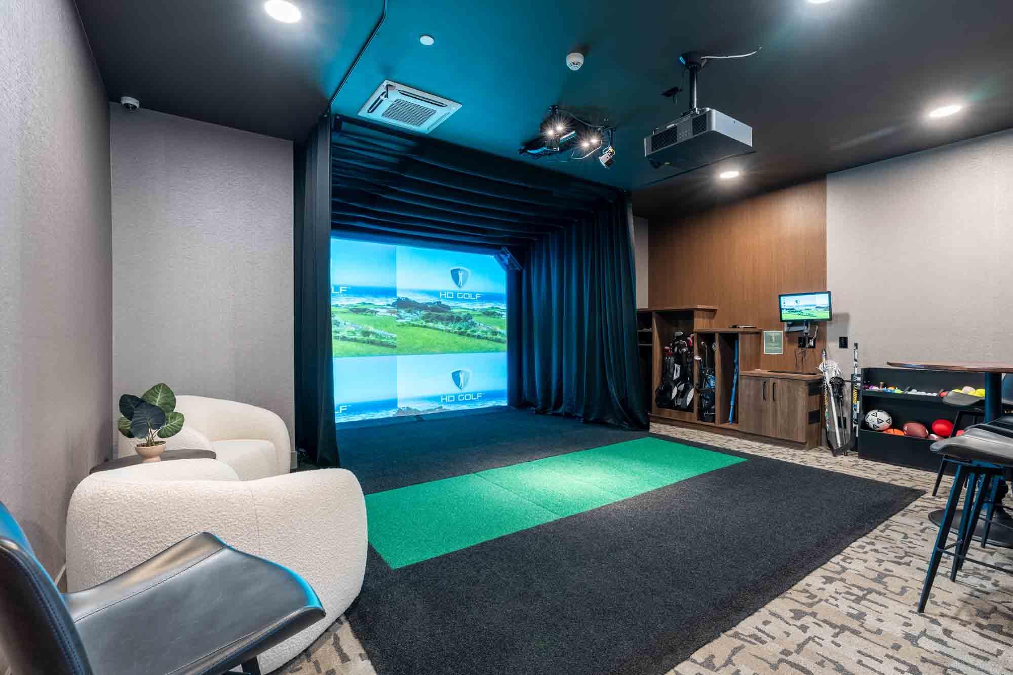 A room with a large screen and a green mat in front of it.
