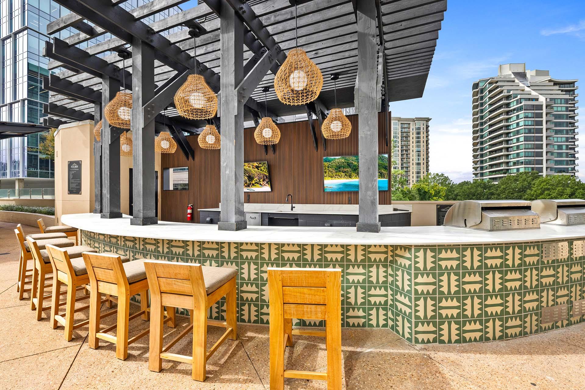 A bar with wooden chairs and a green patterned wall.