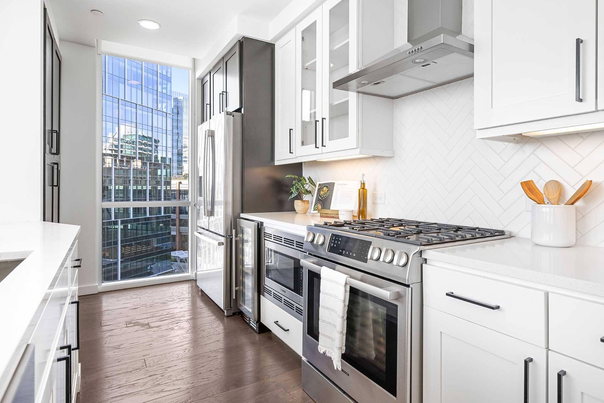 A modern kitchen with stainless steel appliances and white cabinets.