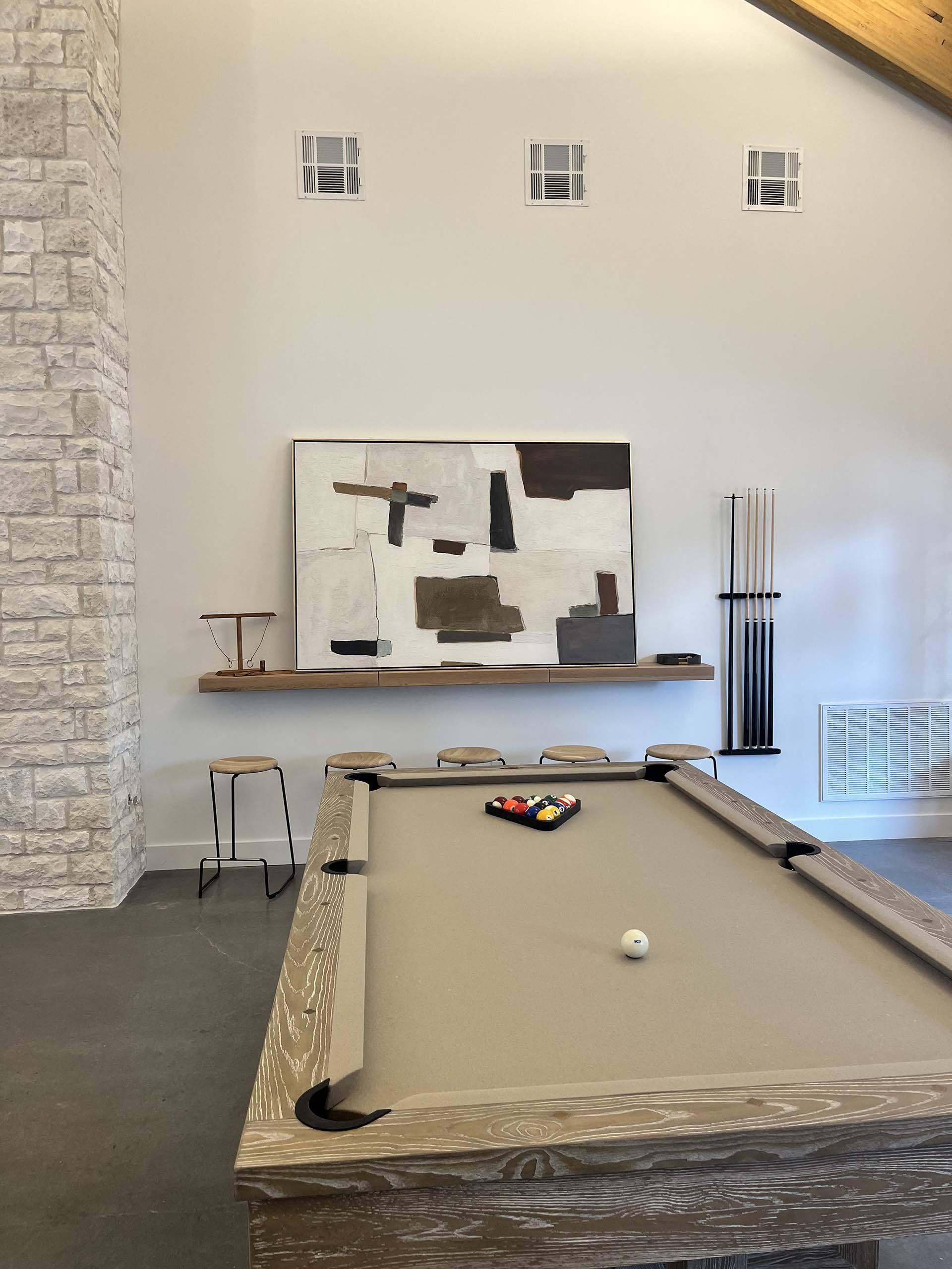 a pool table in a room with a painting on the wall