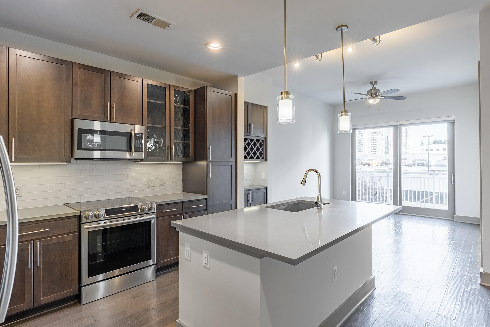 A modern kitchen with a large island and stainless steel appliances.