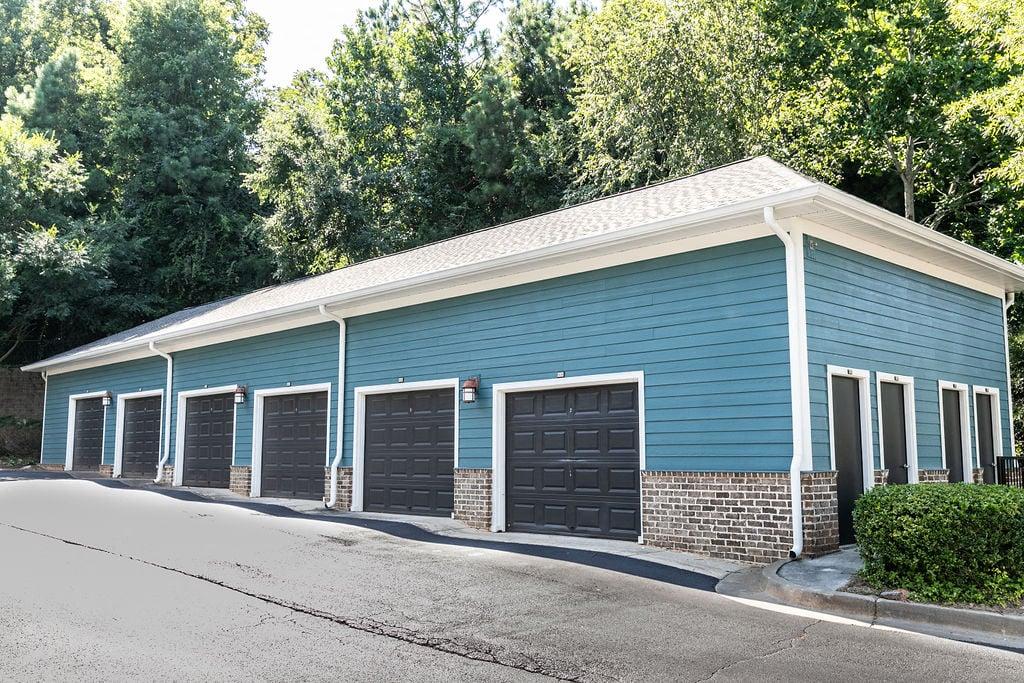 a blue building with three garage doors on the side of a street