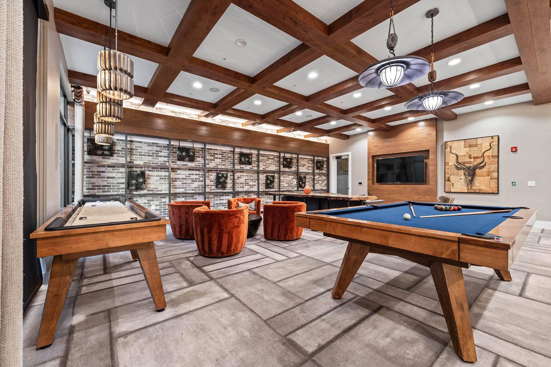 a games room with two pool tables and a television