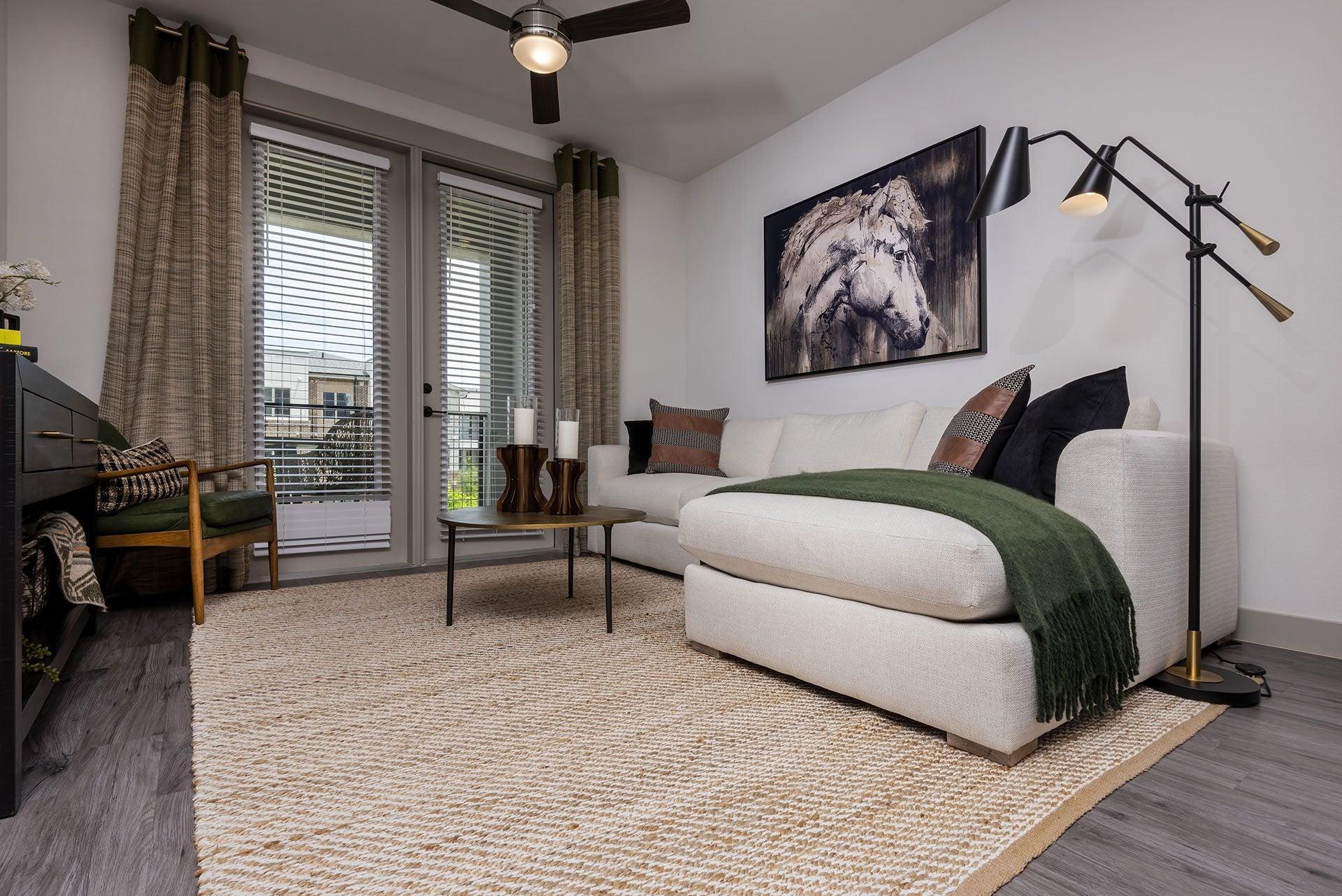A living room with a white couch and a painting of a lion on the wall.