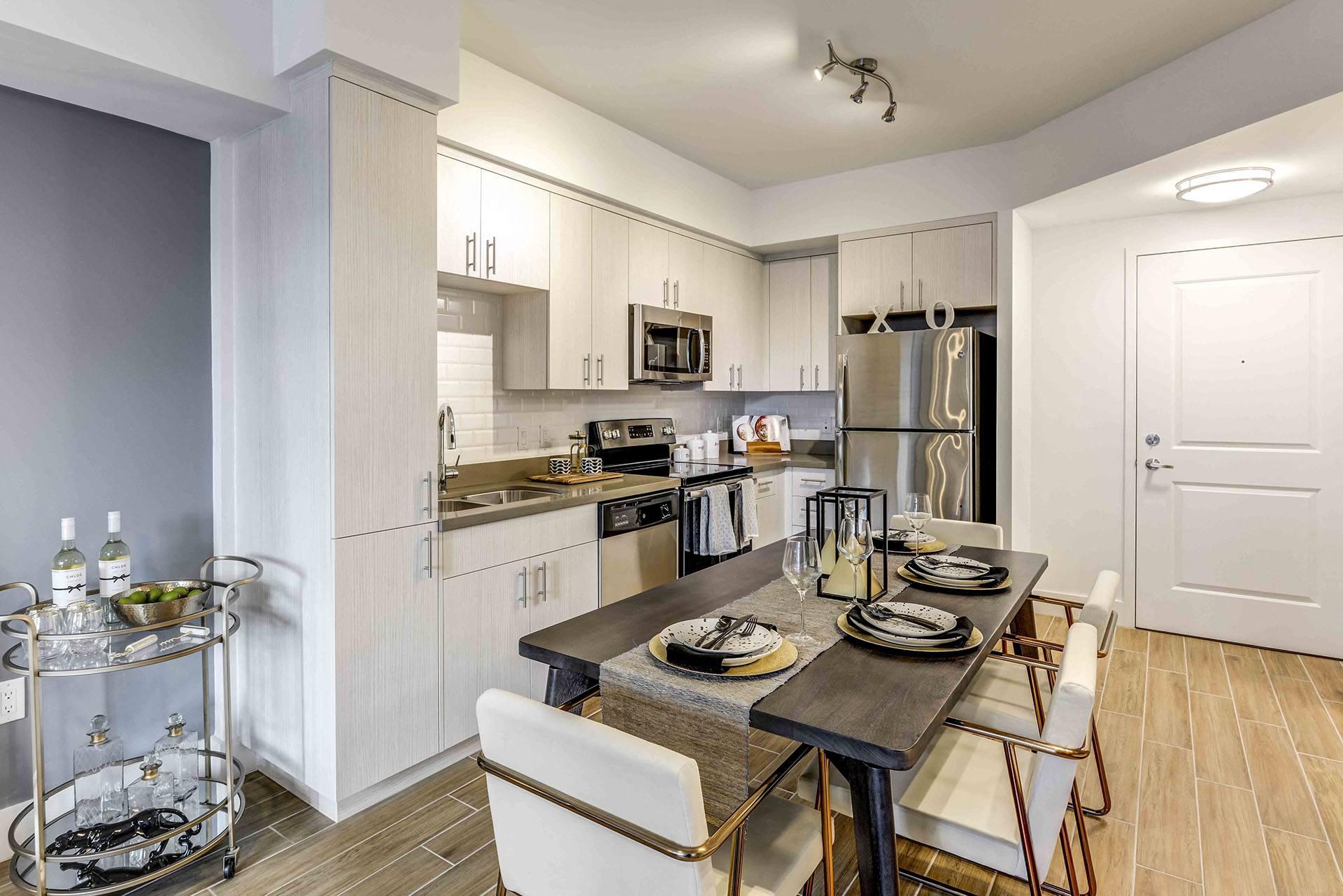 A modern kitchen with a dining table set for two.
