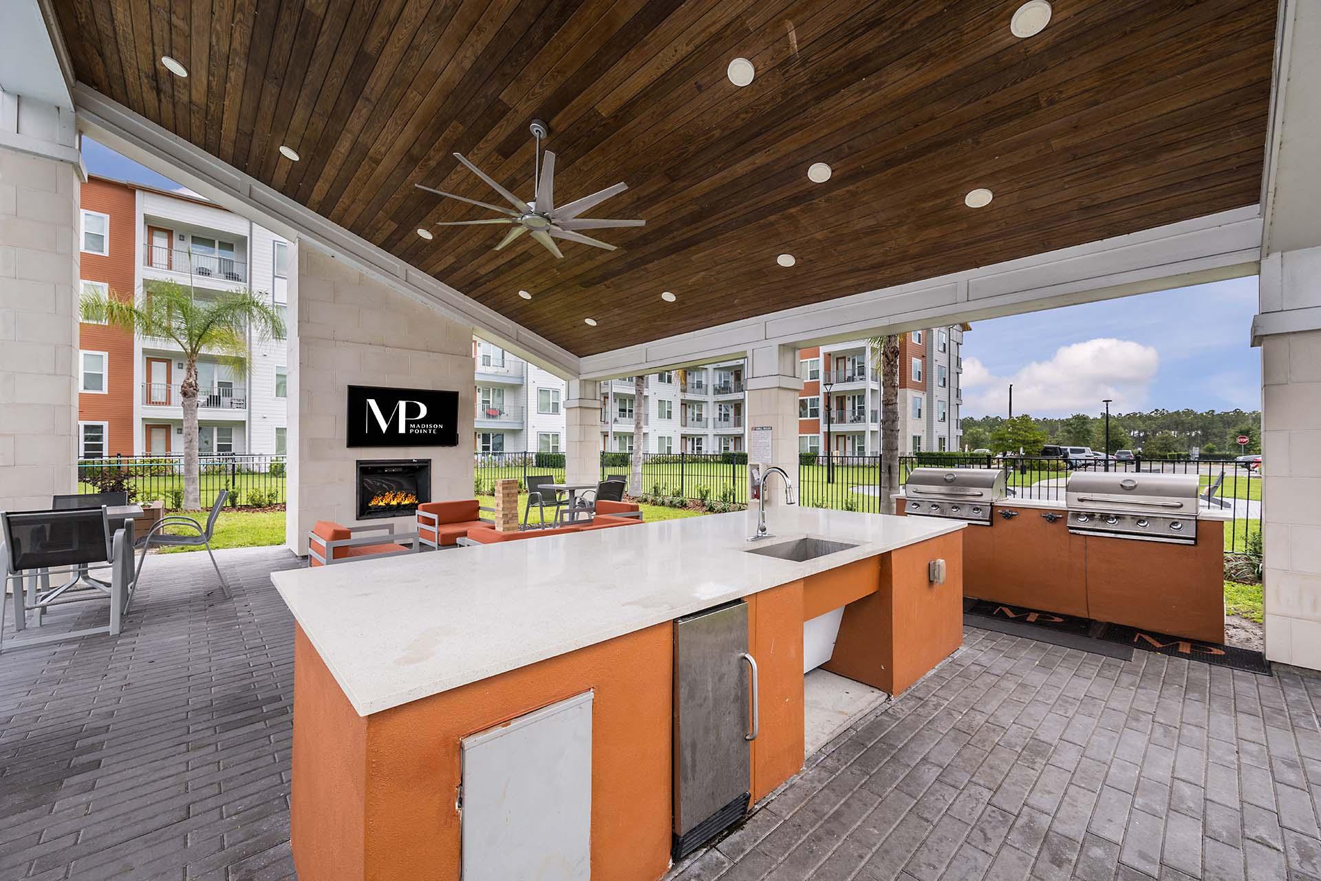 A modern outdoor kitchen with a grill and sink.