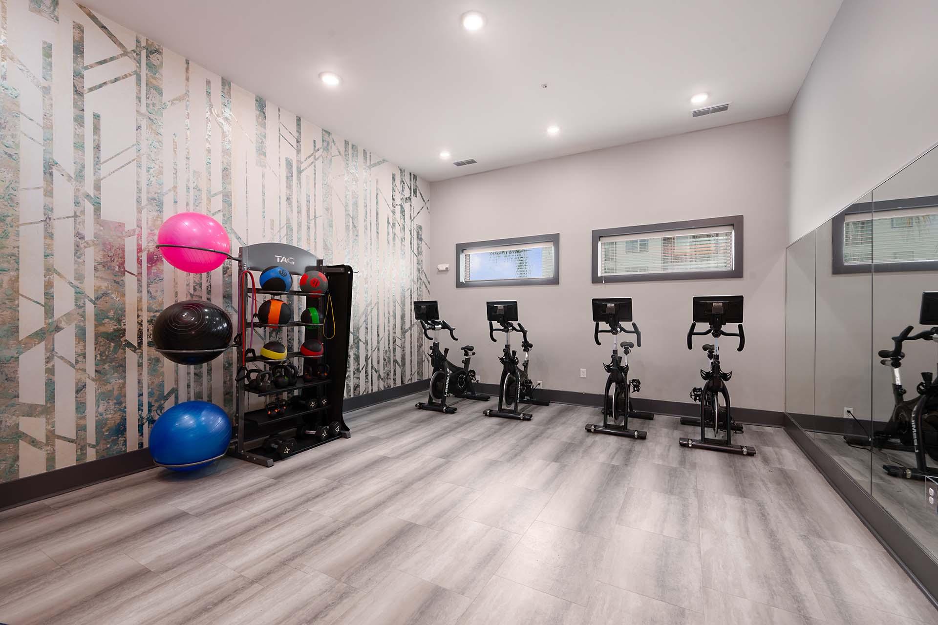 A gym with exercise equipment and a wallpapered wall.