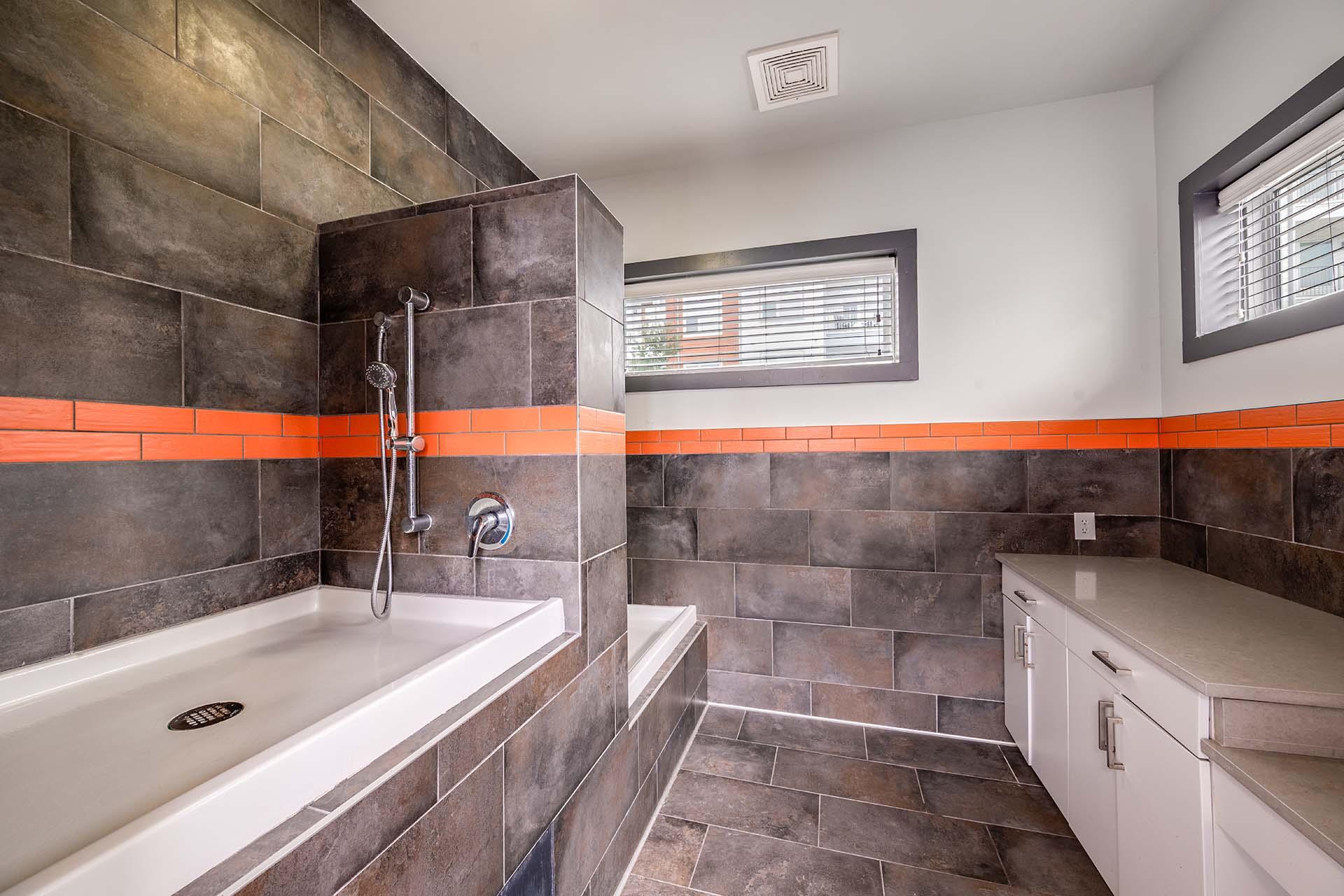 A bathroom with a white tub and a shower with a glass door.