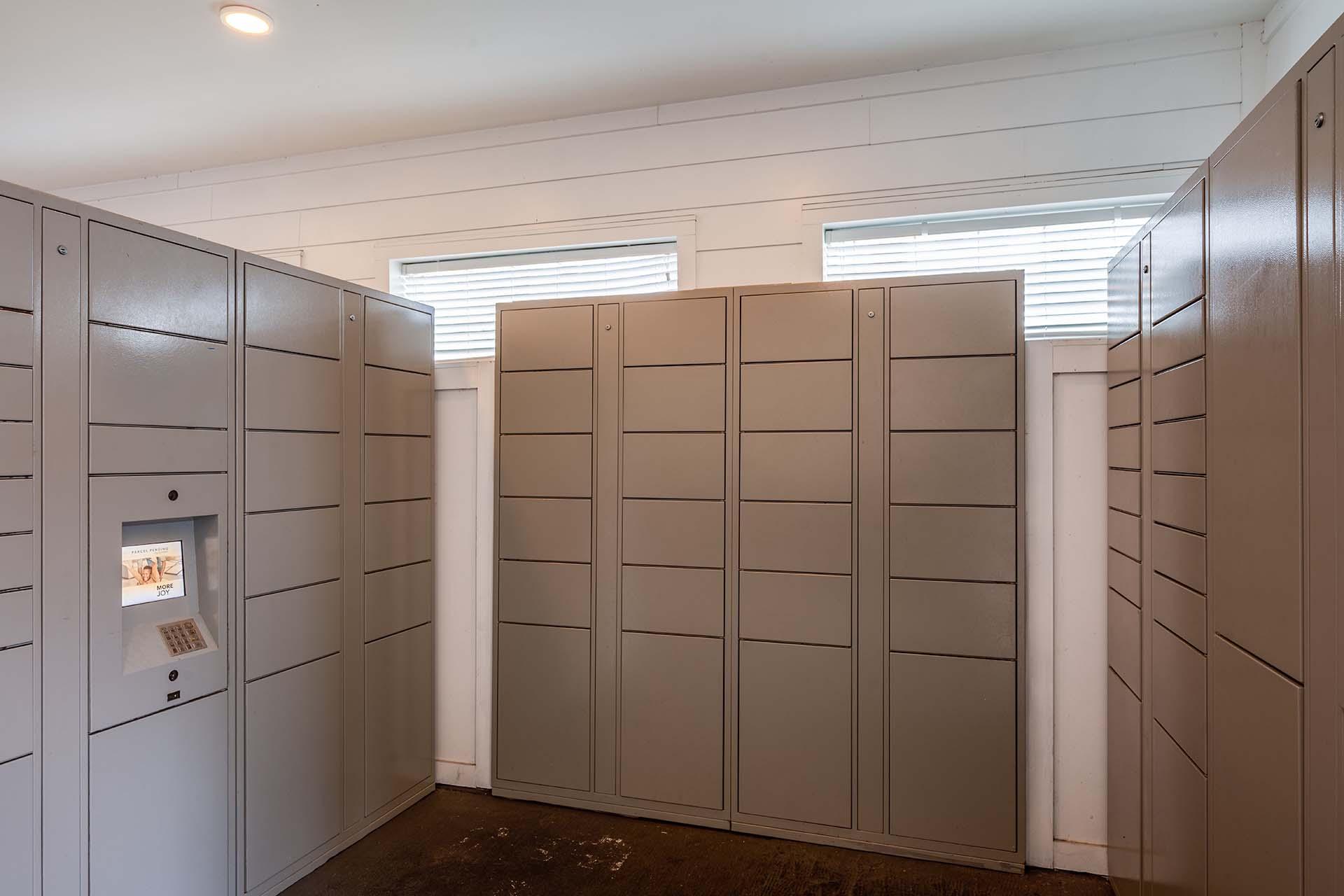 A row of lockers in a room with a white wall.