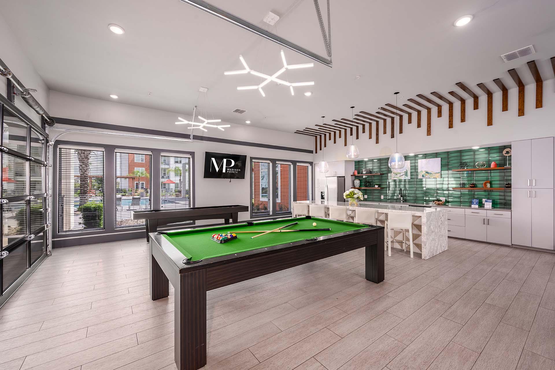A billiard table is in the middle of a room with a pool table light.