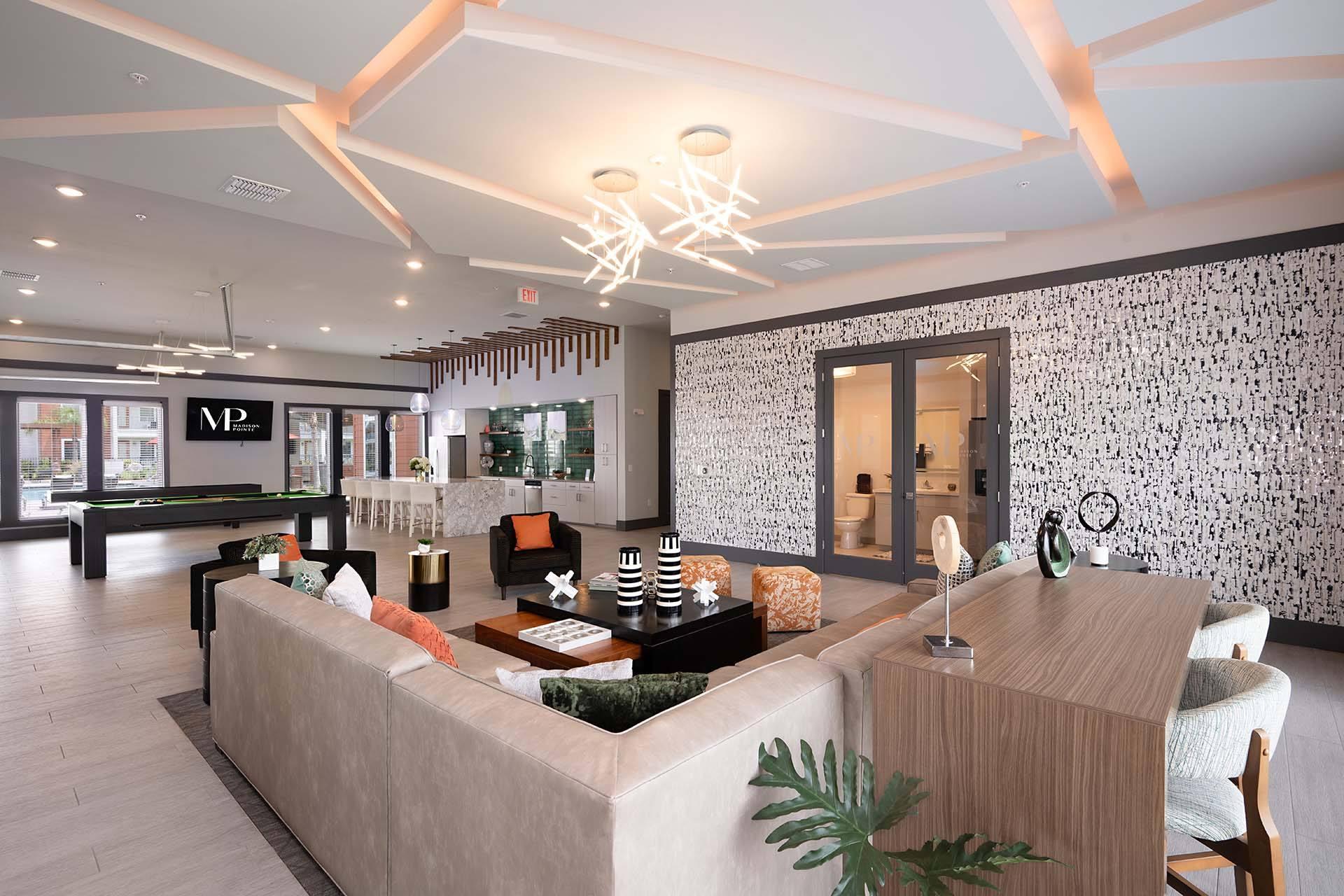 A living room with a large couch and a patterned wallpaper.