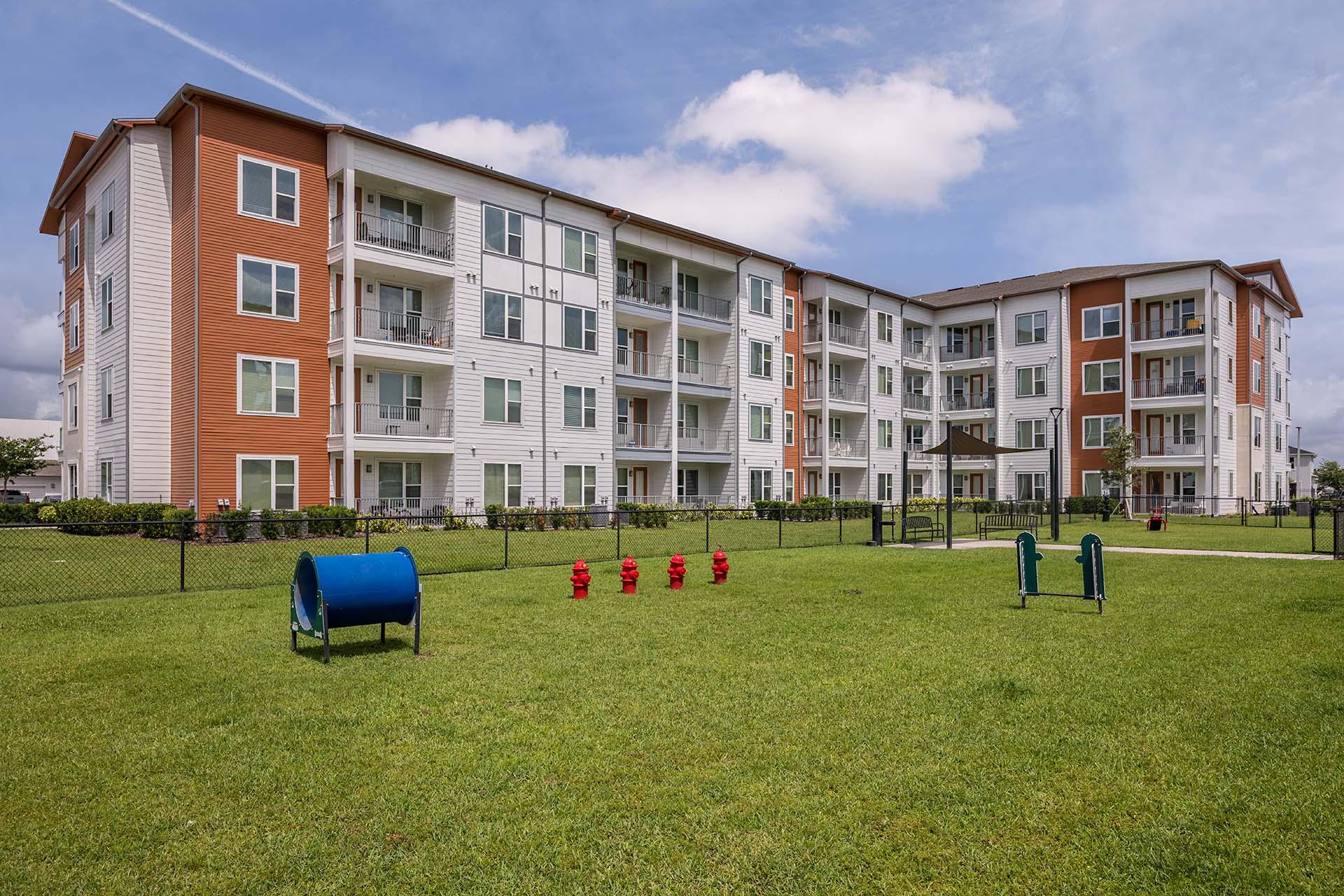 A large apartment complex with a green lawn in front.