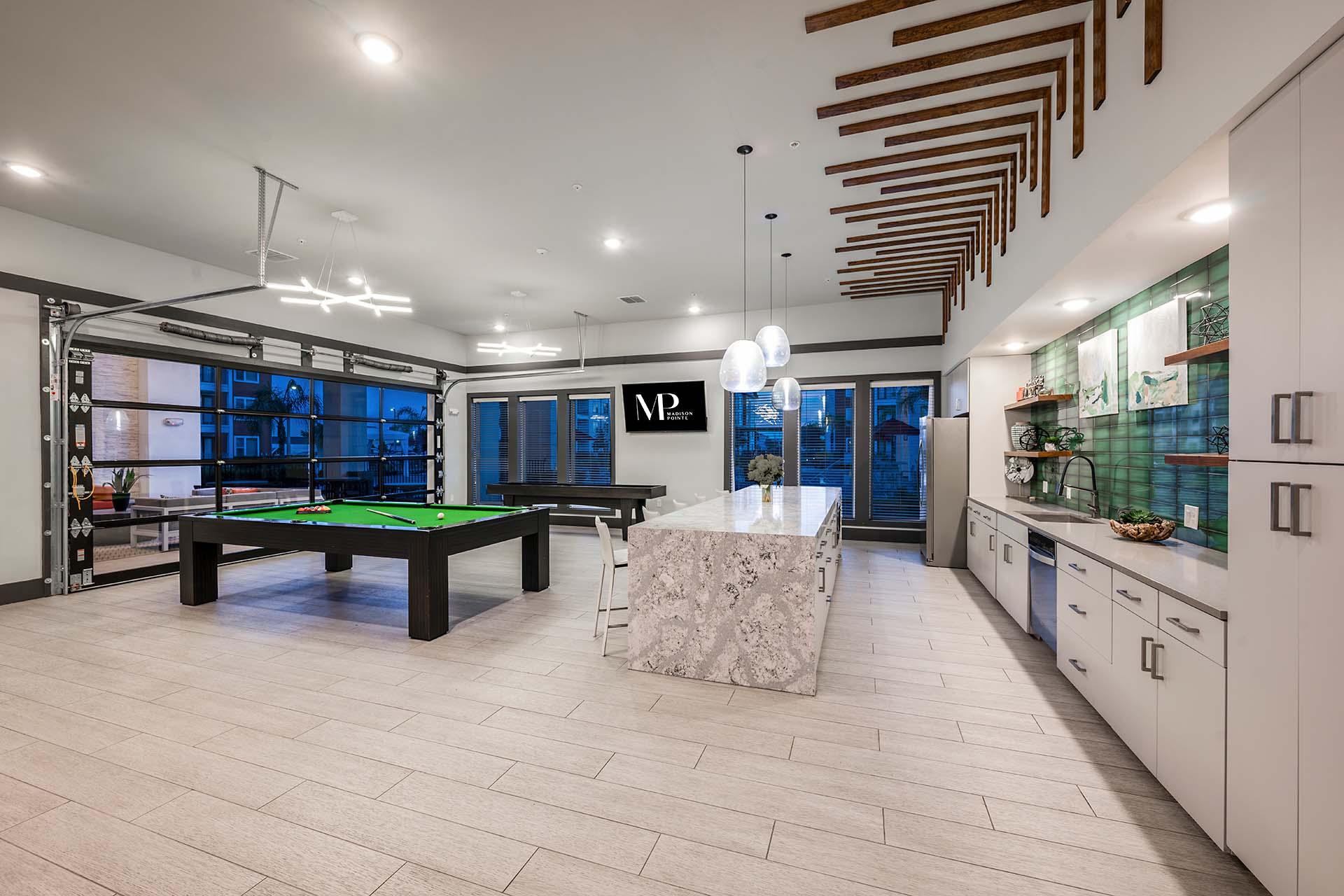 A billiard table is in the middle of a room with a pool table.