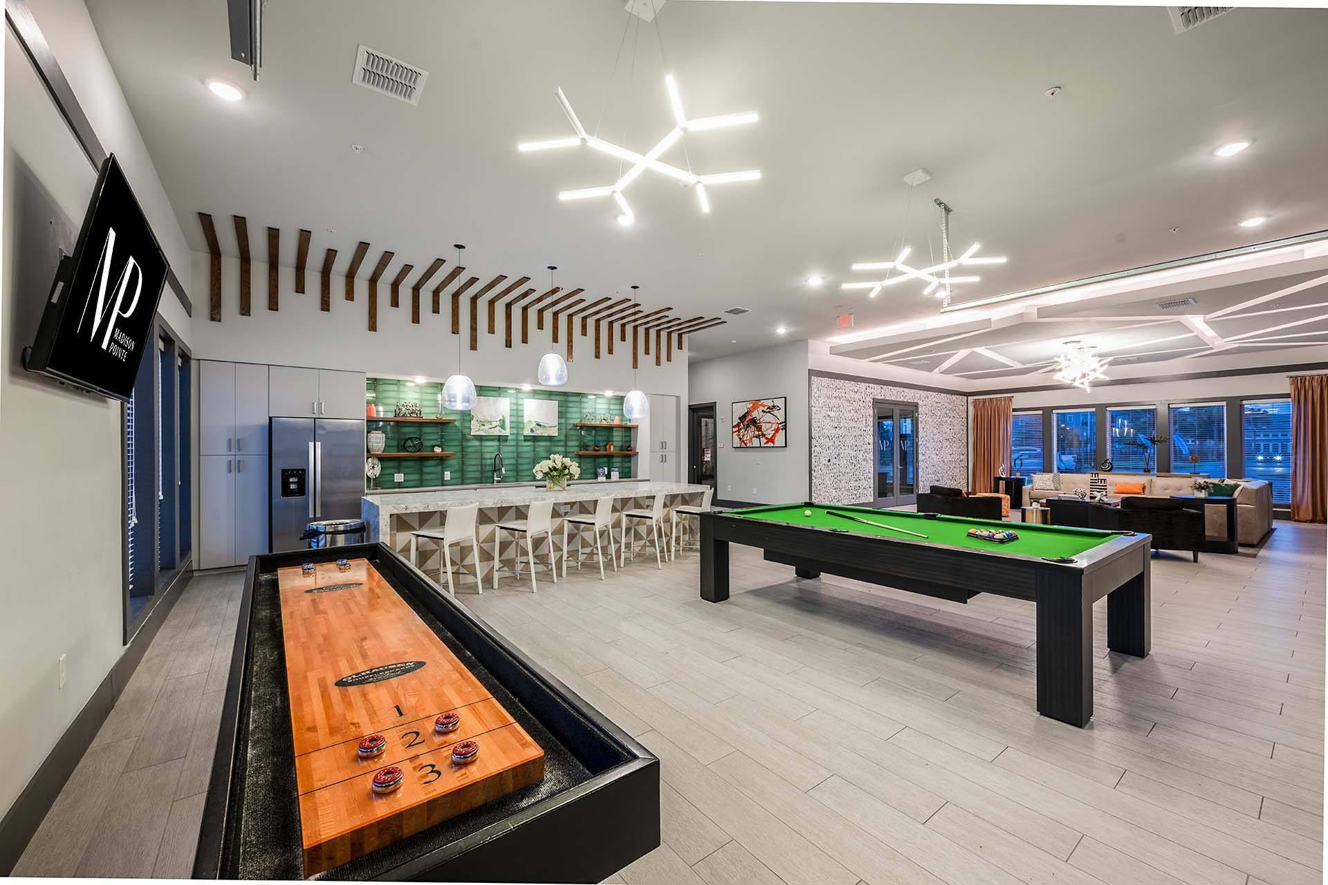 A room with a pool table and a shuffleboard table.