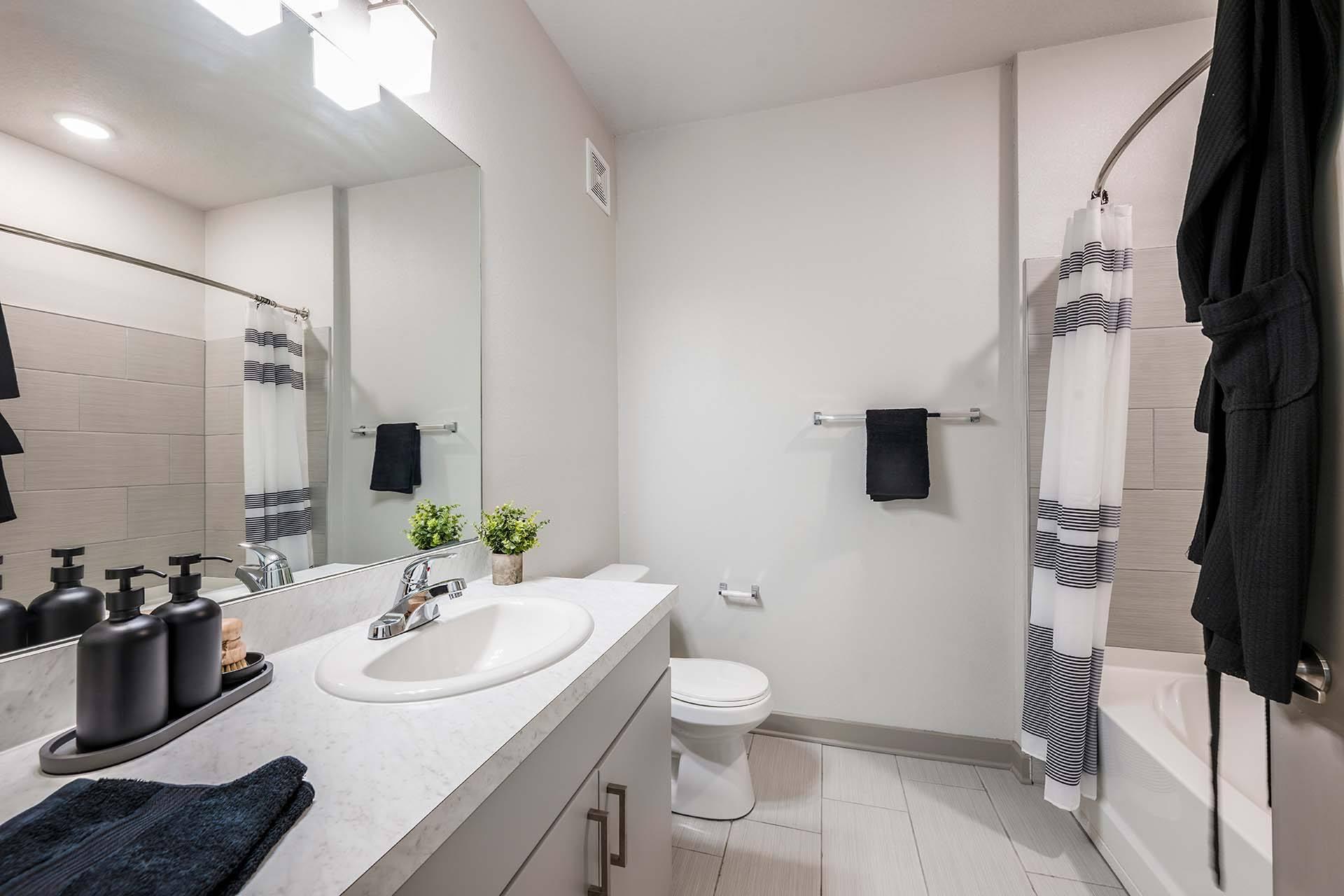 A bathroom with a white toilet, sink, and a mirror.