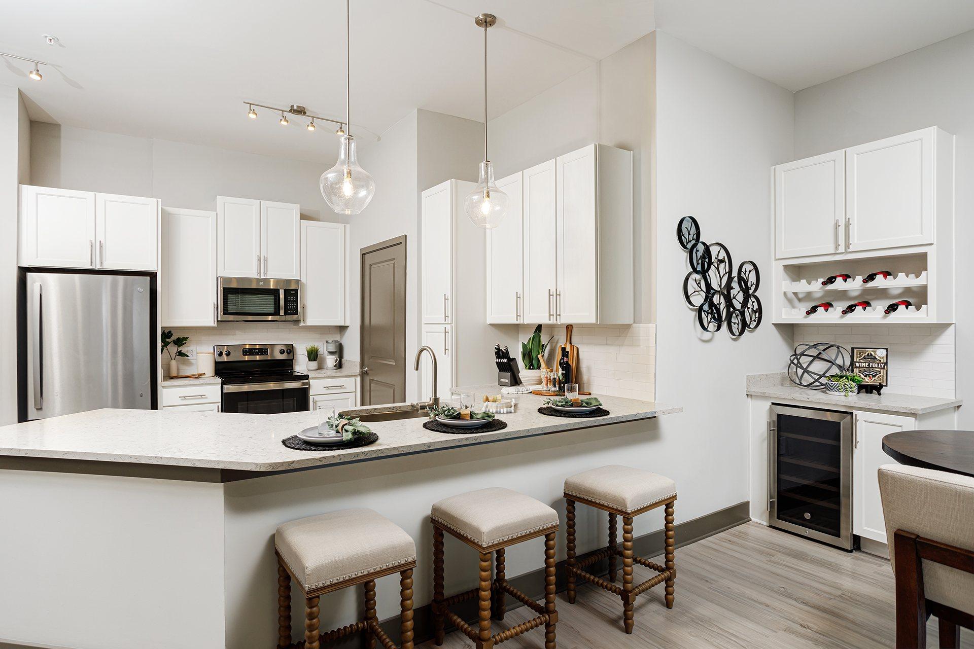 A modern kitchen with white cabinets and a large island.