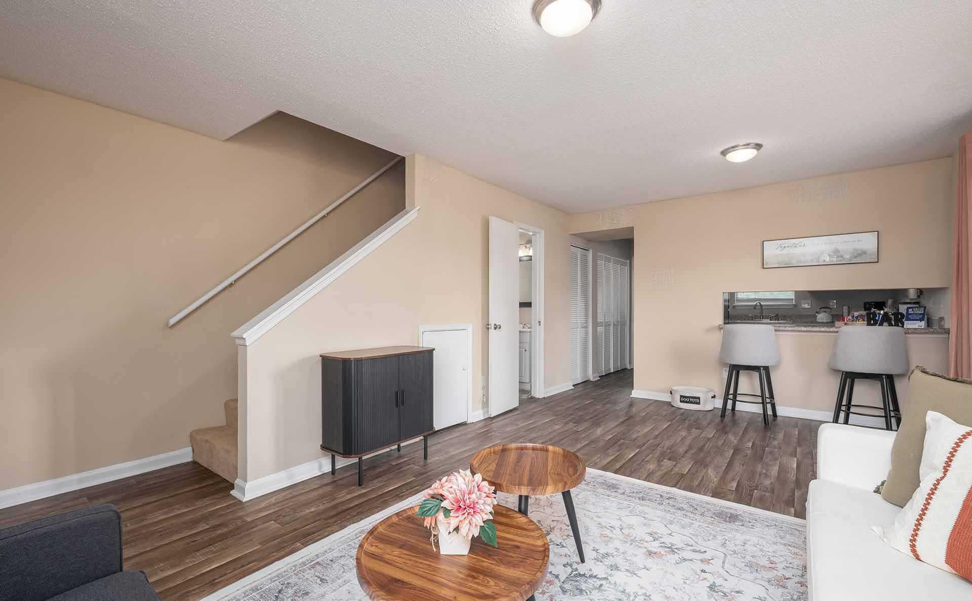 A living room with a staircase and a flat screen TV.