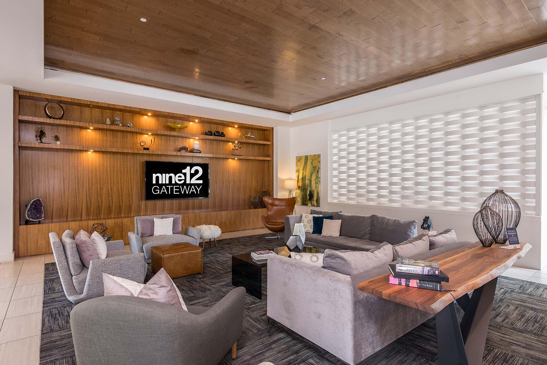 A living room with a wooden ceiling and a sign that says "nine12 GATEWAY".