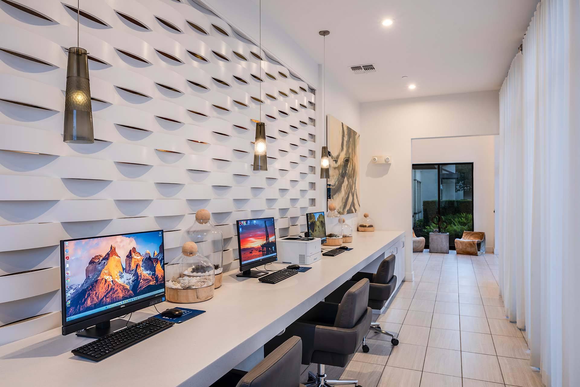 A modern home office with a white desk and two computer monitors.