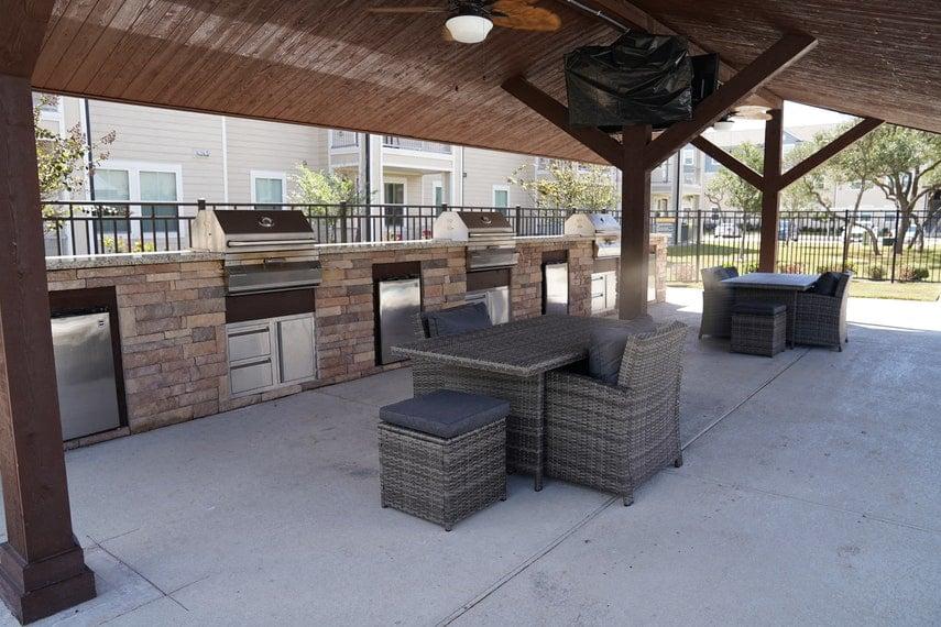 A patio with a table and chairs under a roof.