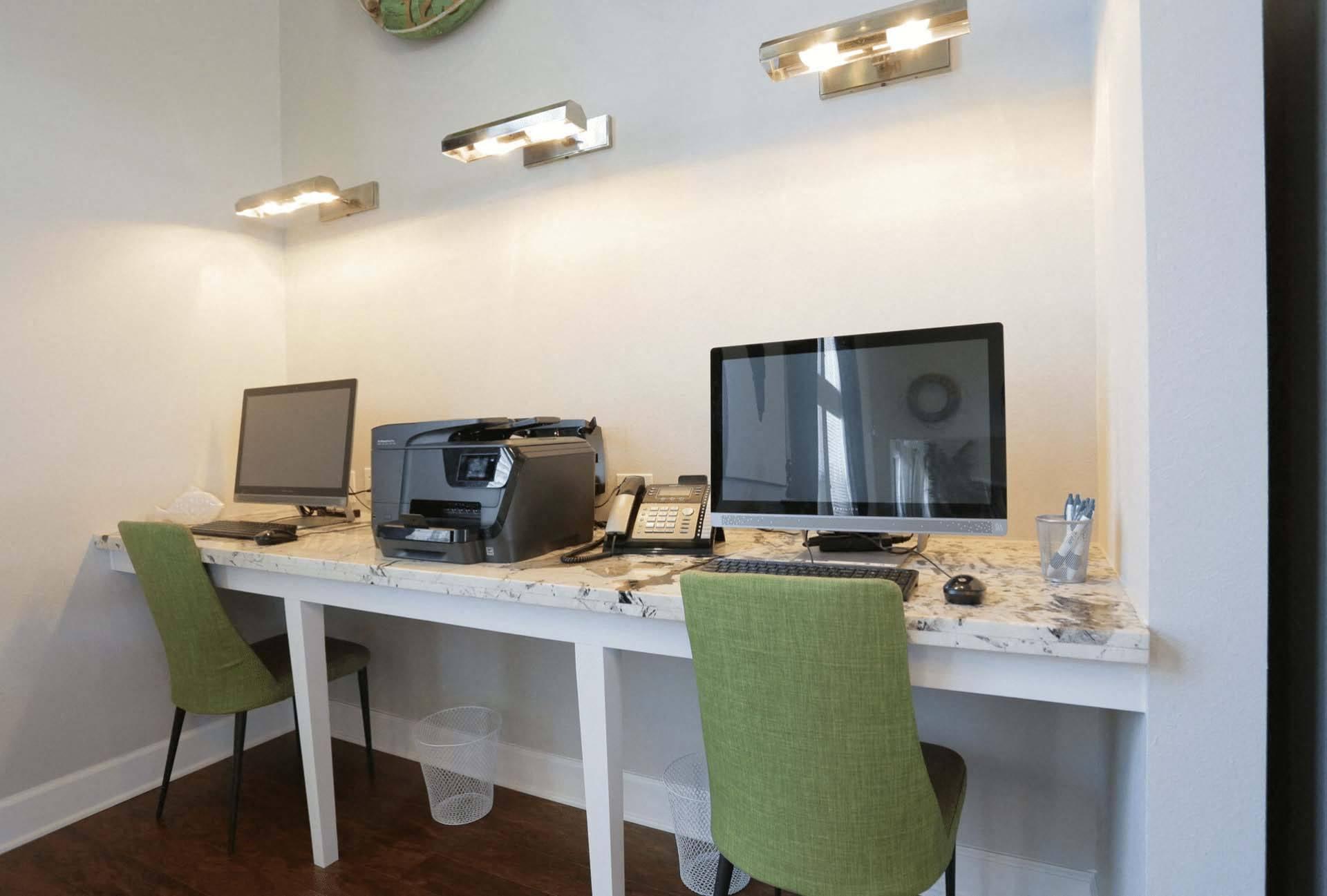 A white desk with a laptop, monitor, and printer on it.