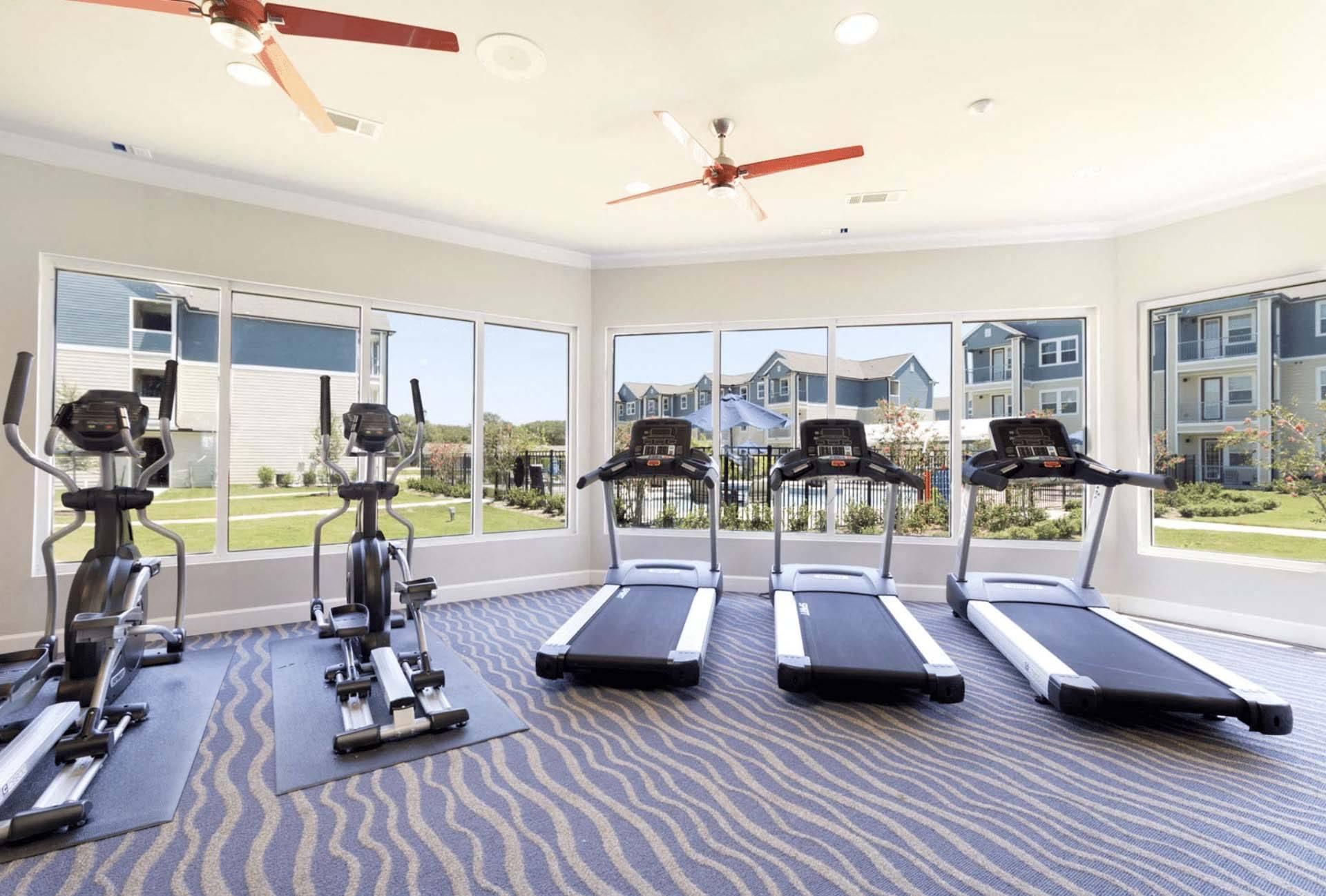 A gym with treadmills and elliptical machines.