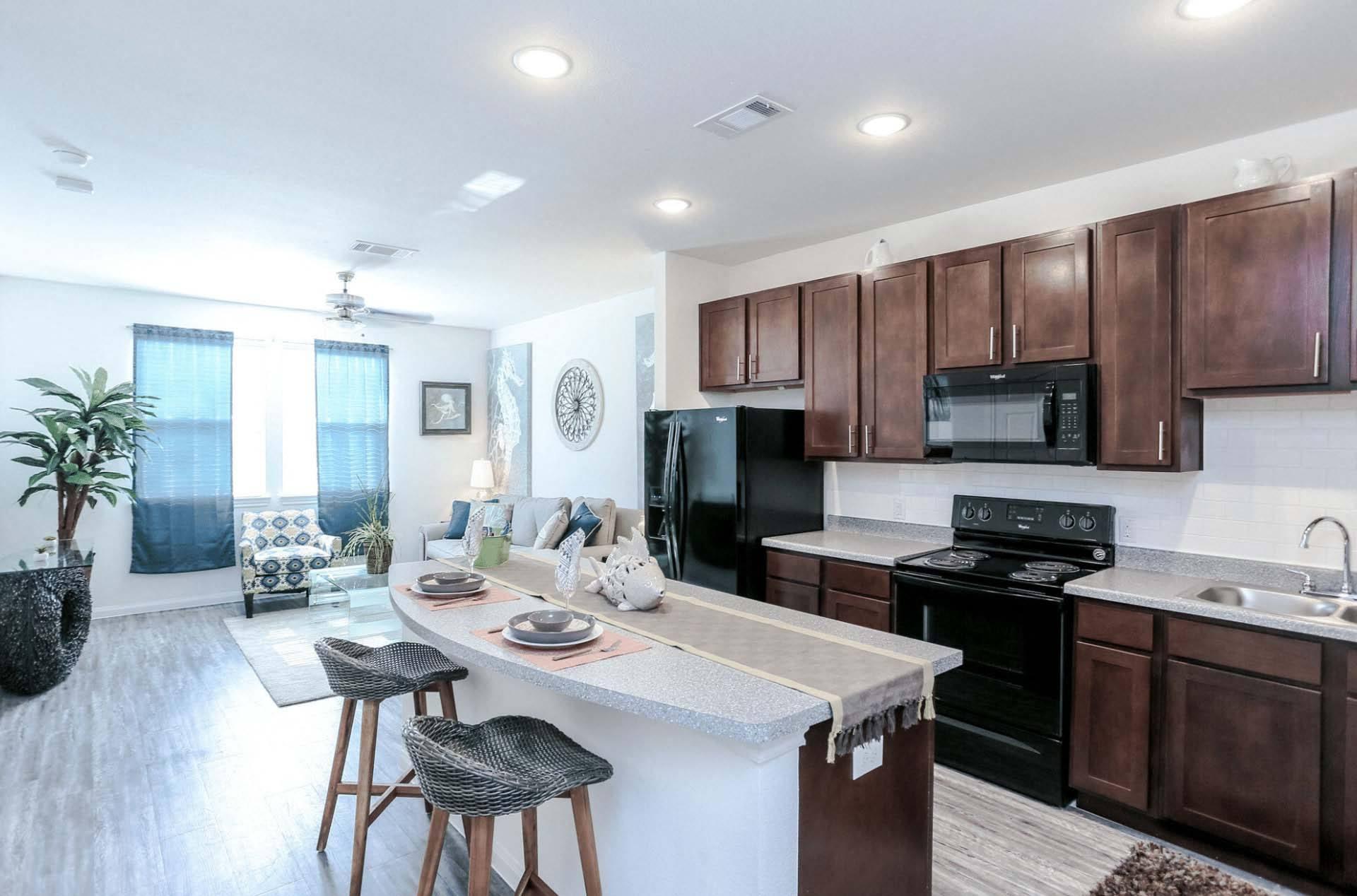A kitchen with brown cabinets and black appliances.