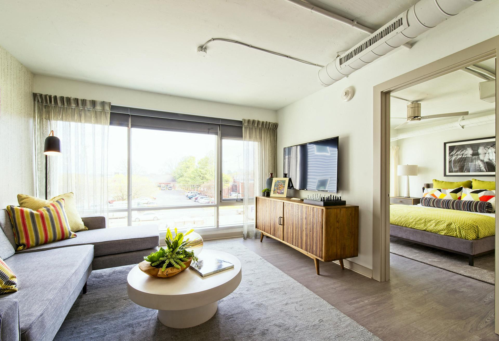 a living room with a couch and a coffee table    and a bedroom