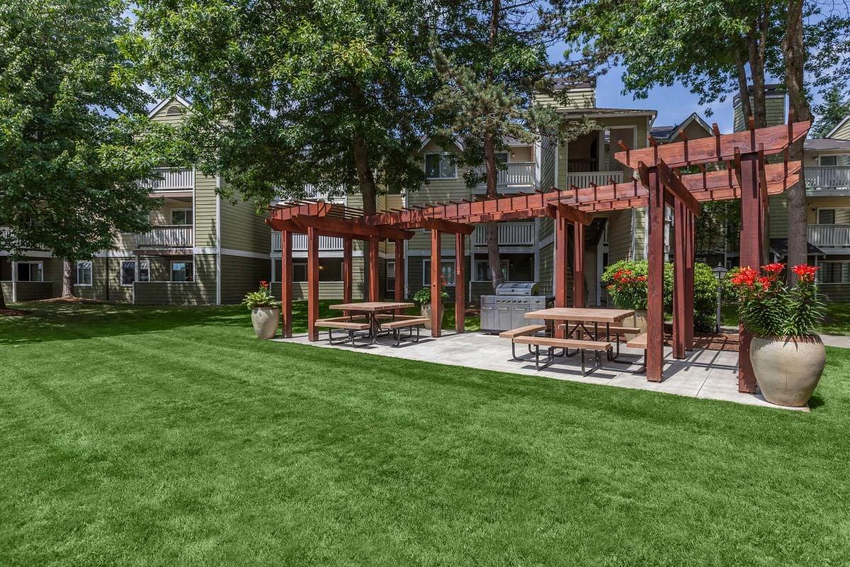 An outdoor area with a grill and tables.
