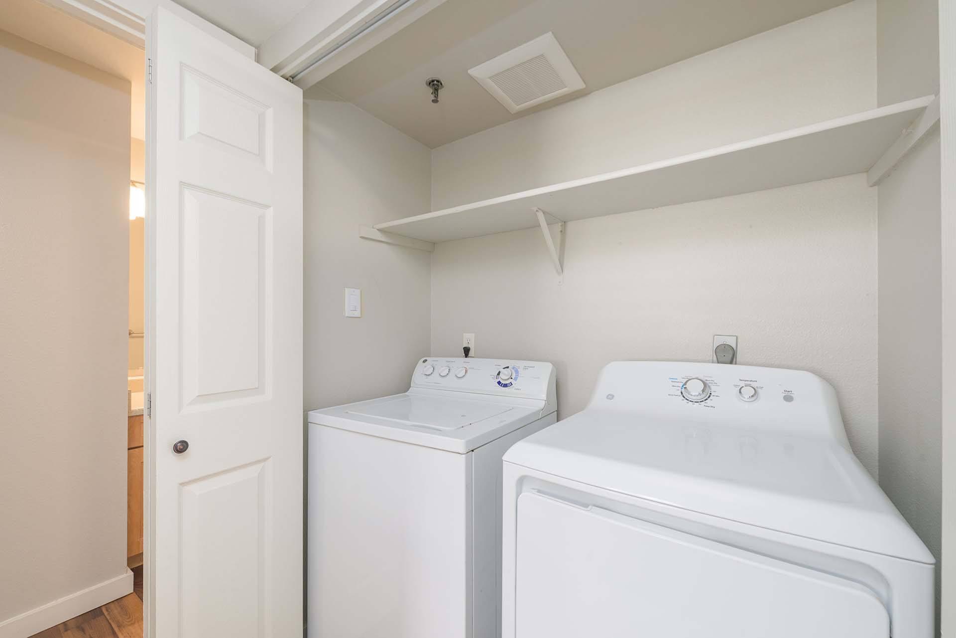 A small laundry room with a washer and dryer.