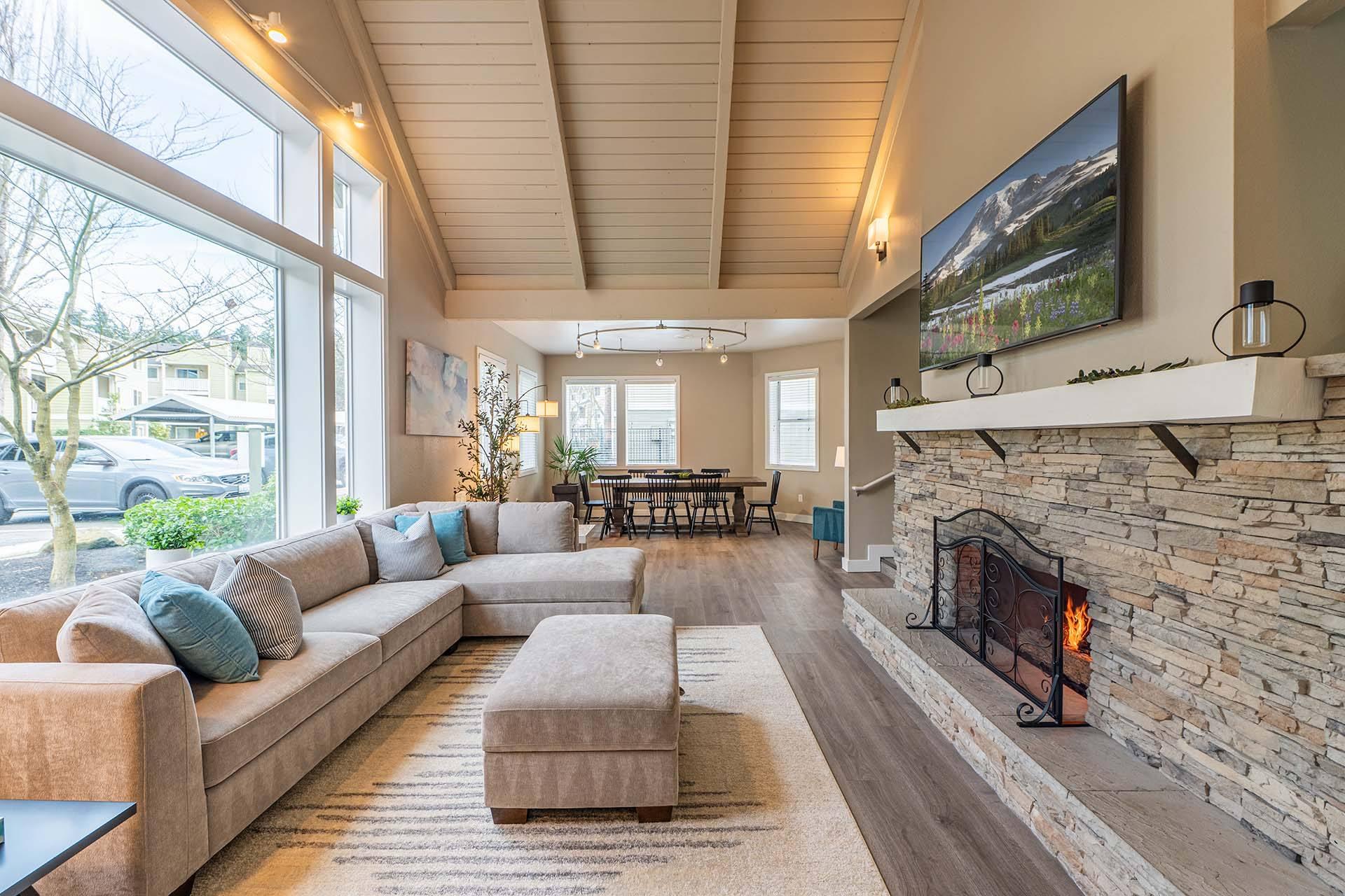 A living room with a stone fireplace and a large couch.