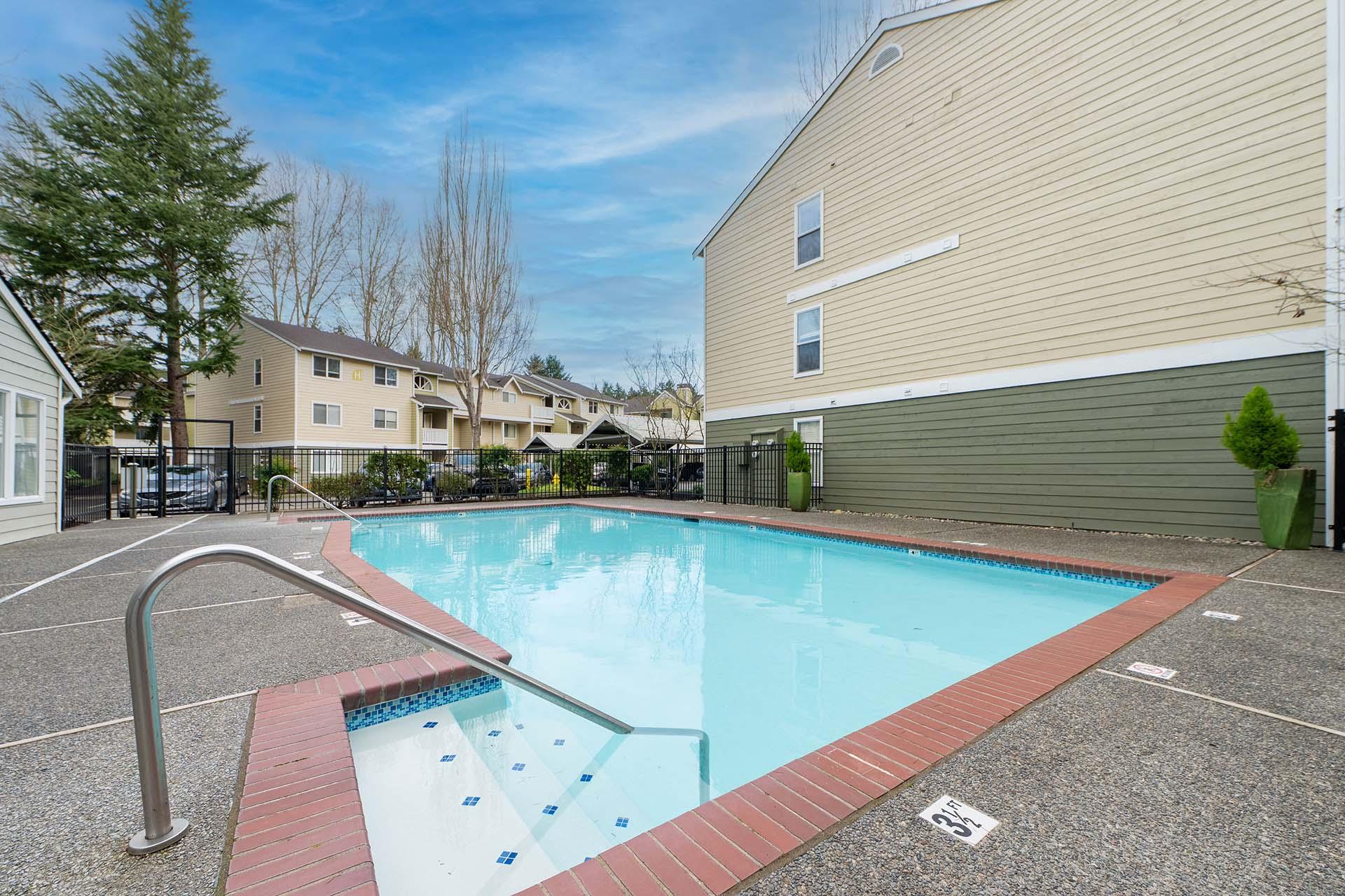 A small pool with a red border and a metal handrail.