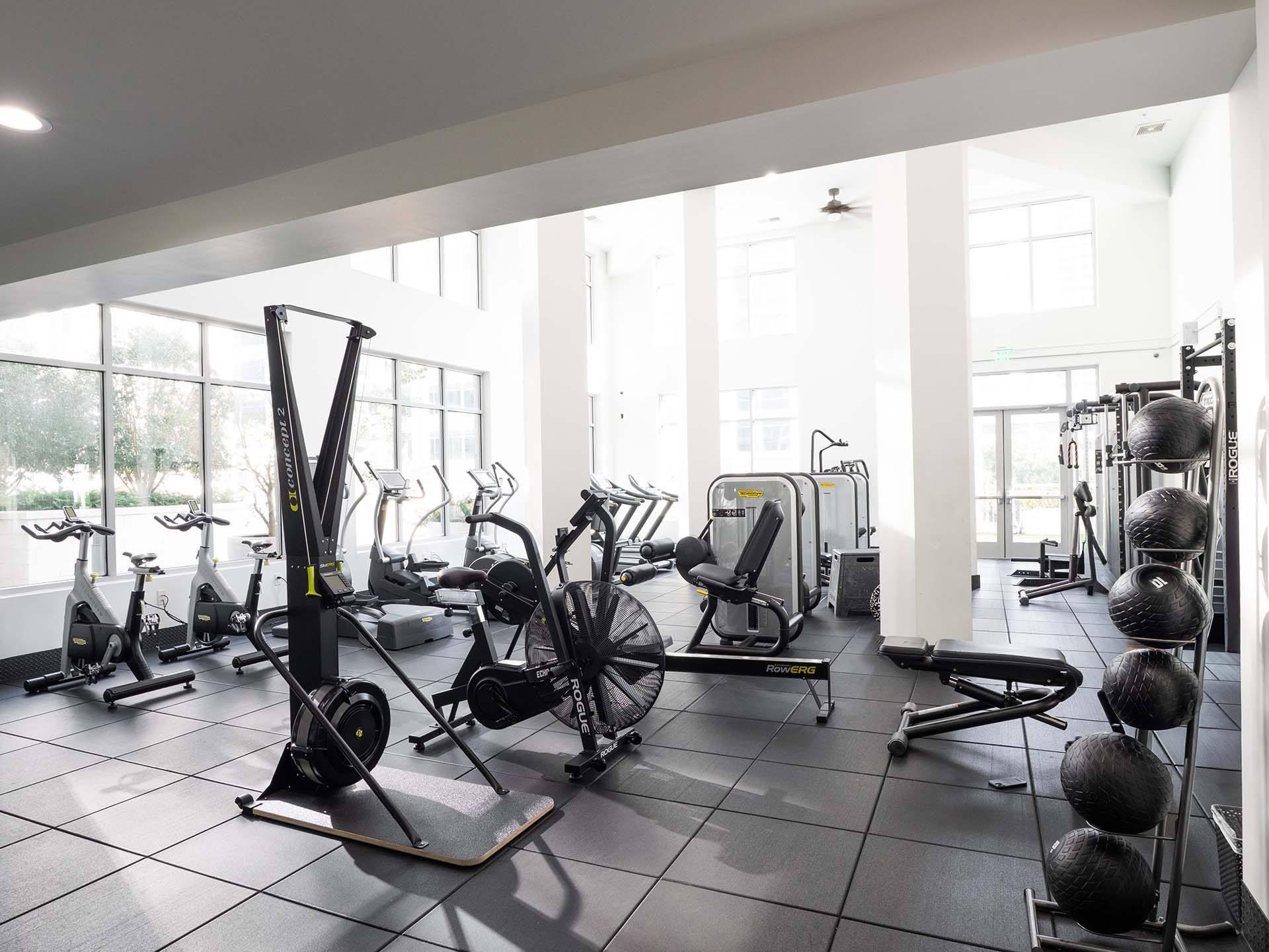 A gym with a variety of equipment including treadmills, stationary bikes, and weight machines.