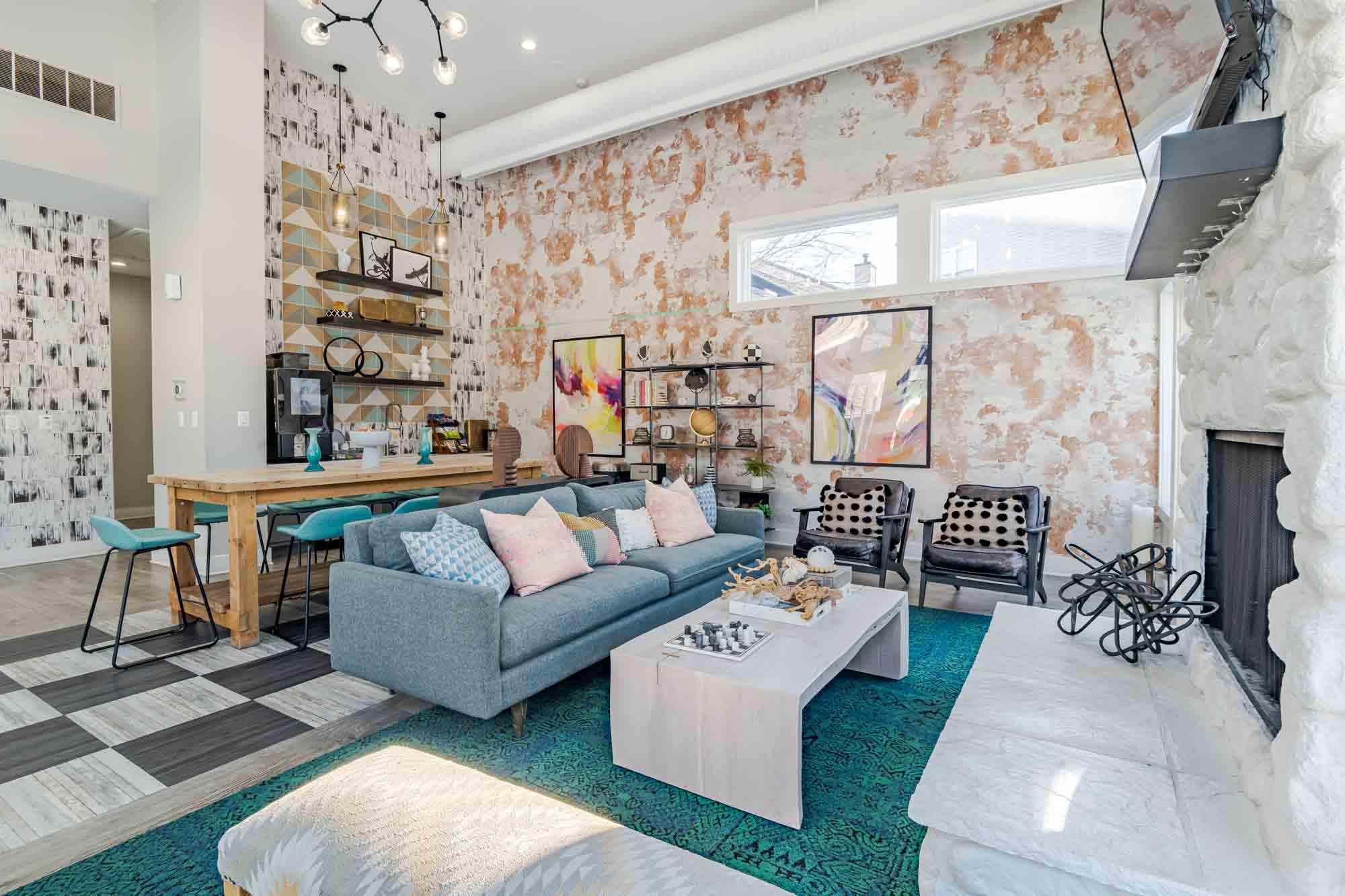 A living room with a grey couch and a white fireplace.