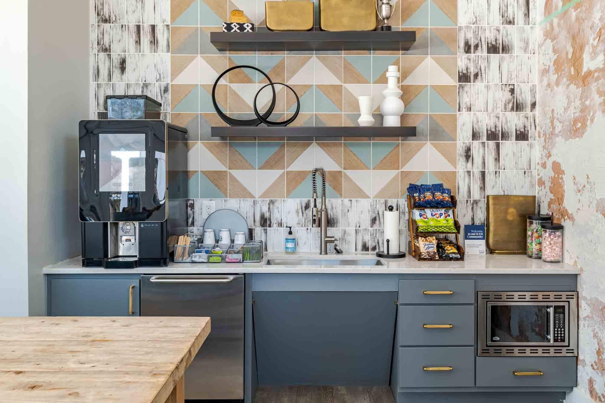 A kitchen with a wooden table in front of a blue and white tiled wall.