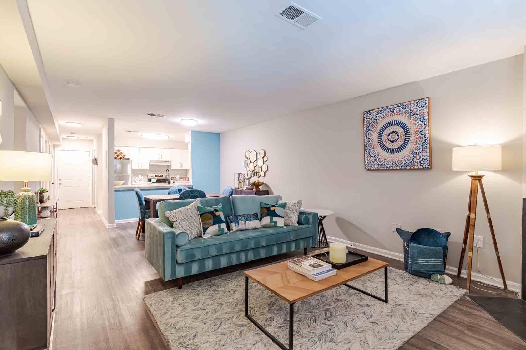 A living room with a blue couch and a rug.