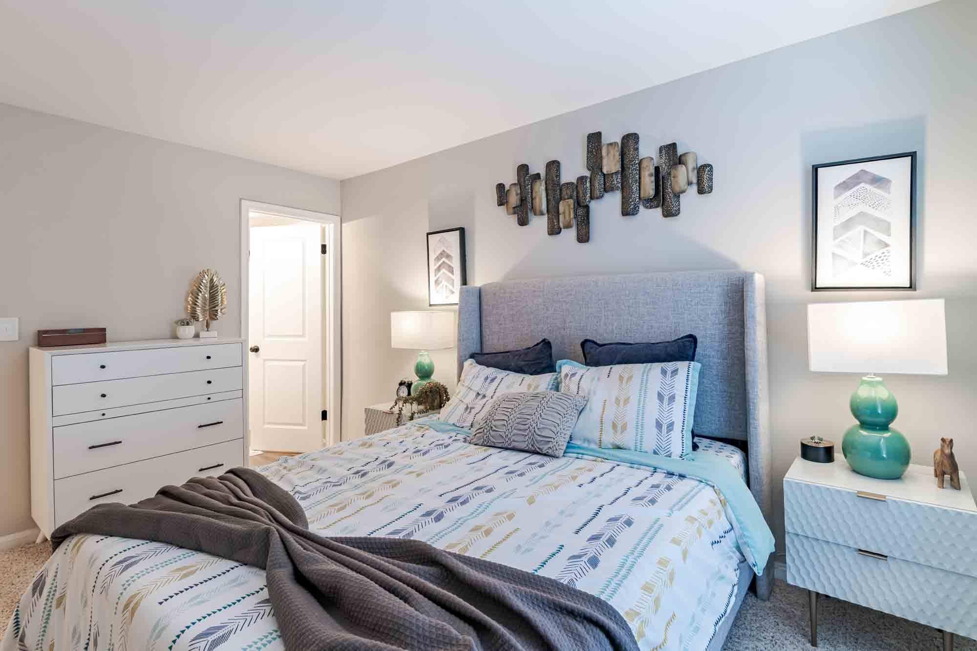 A bedroom with a large bed and a dresser.