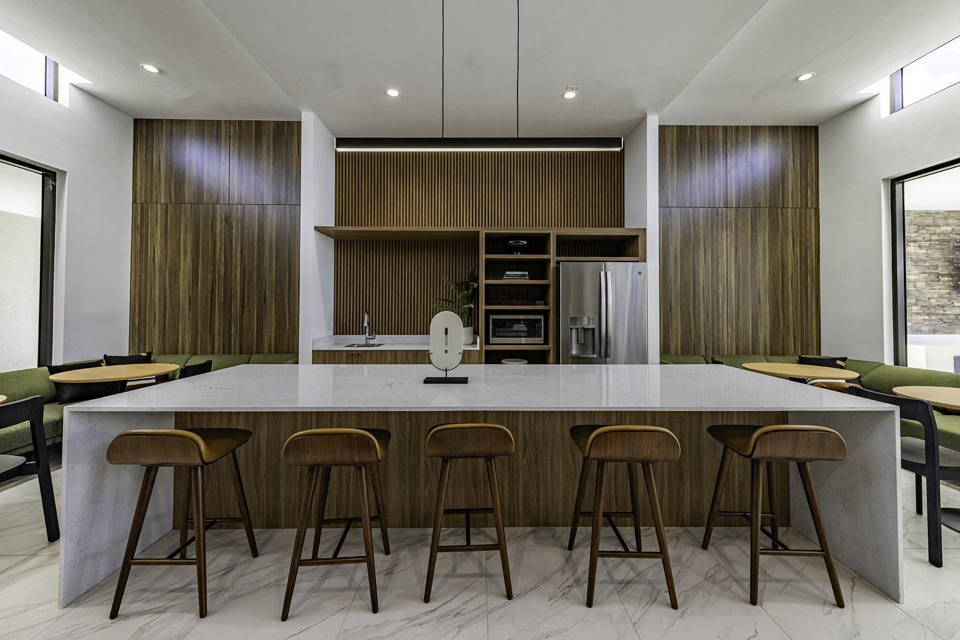 A modern kitchen with a long island and stools.