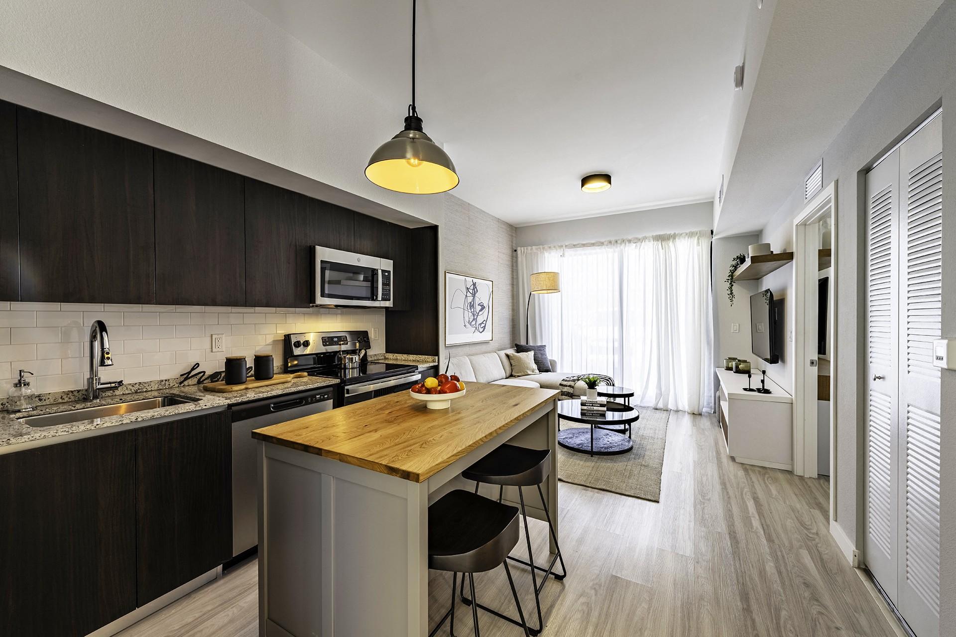 A modern kitchen with dark wood cabinets and a wooden island.