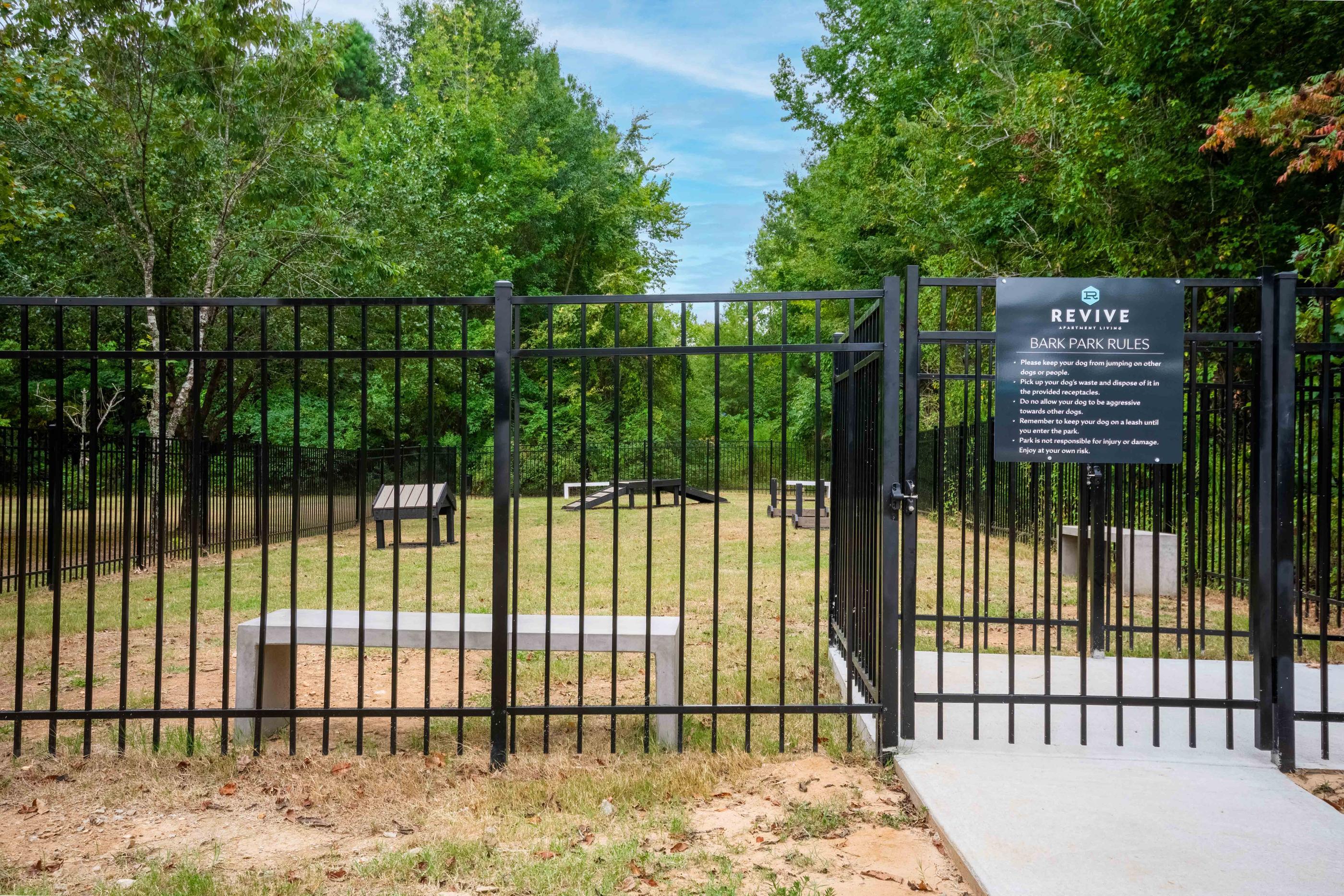 a gate to a park with a bench behind it