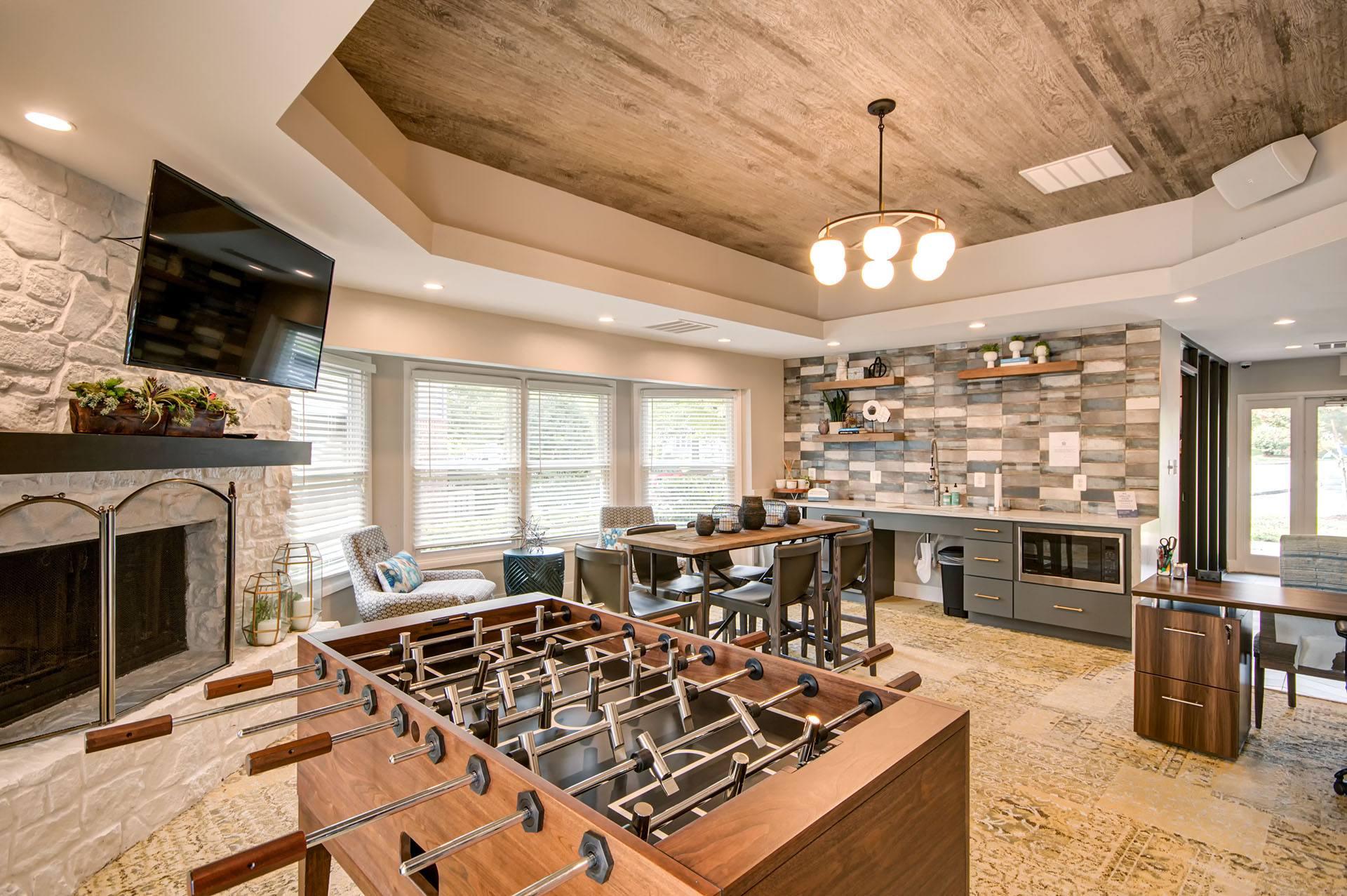 A modern kitchen with a stone fireplace and a wooden stove top.