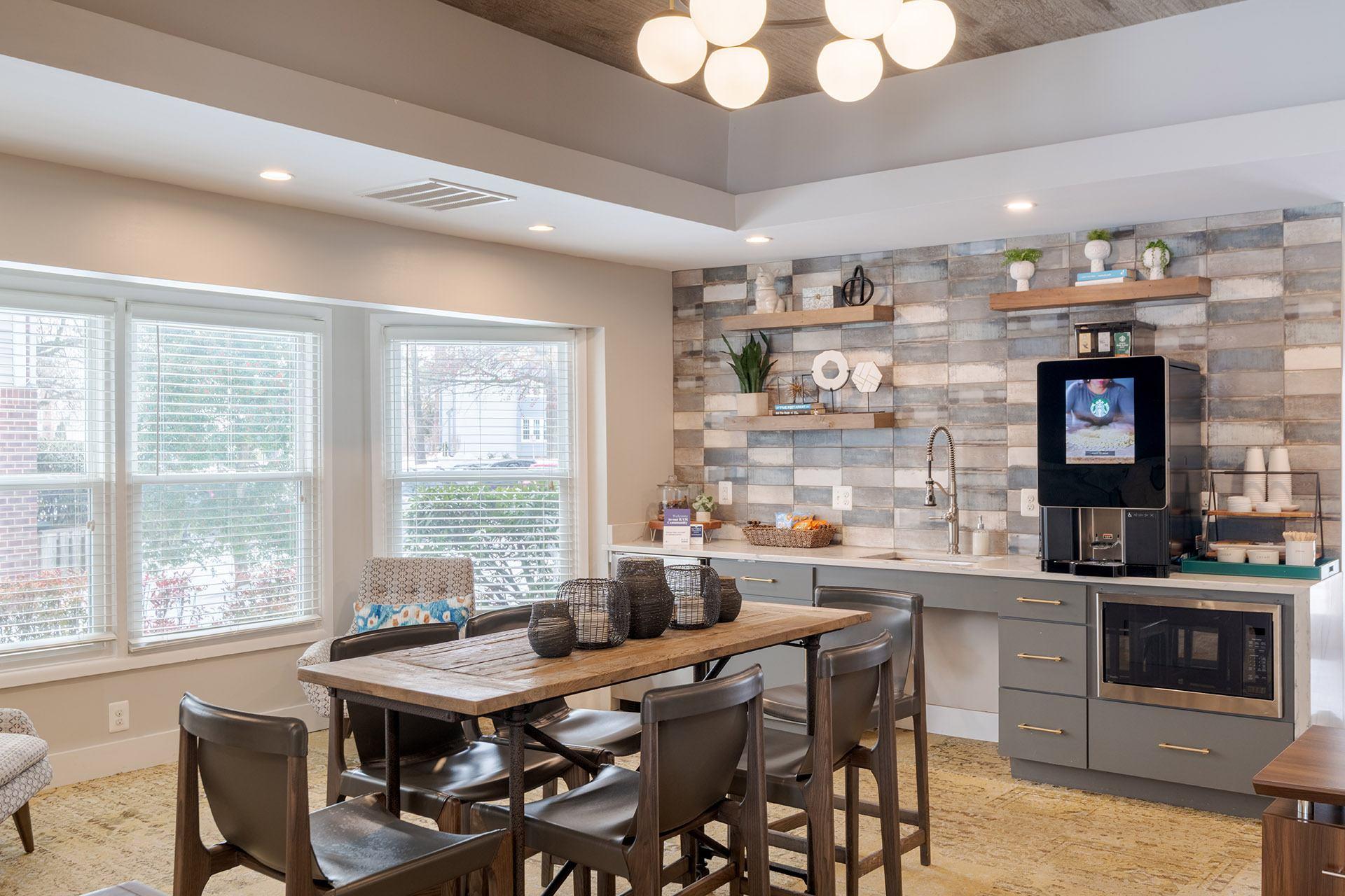 A kitchen with a dining table and chairs.