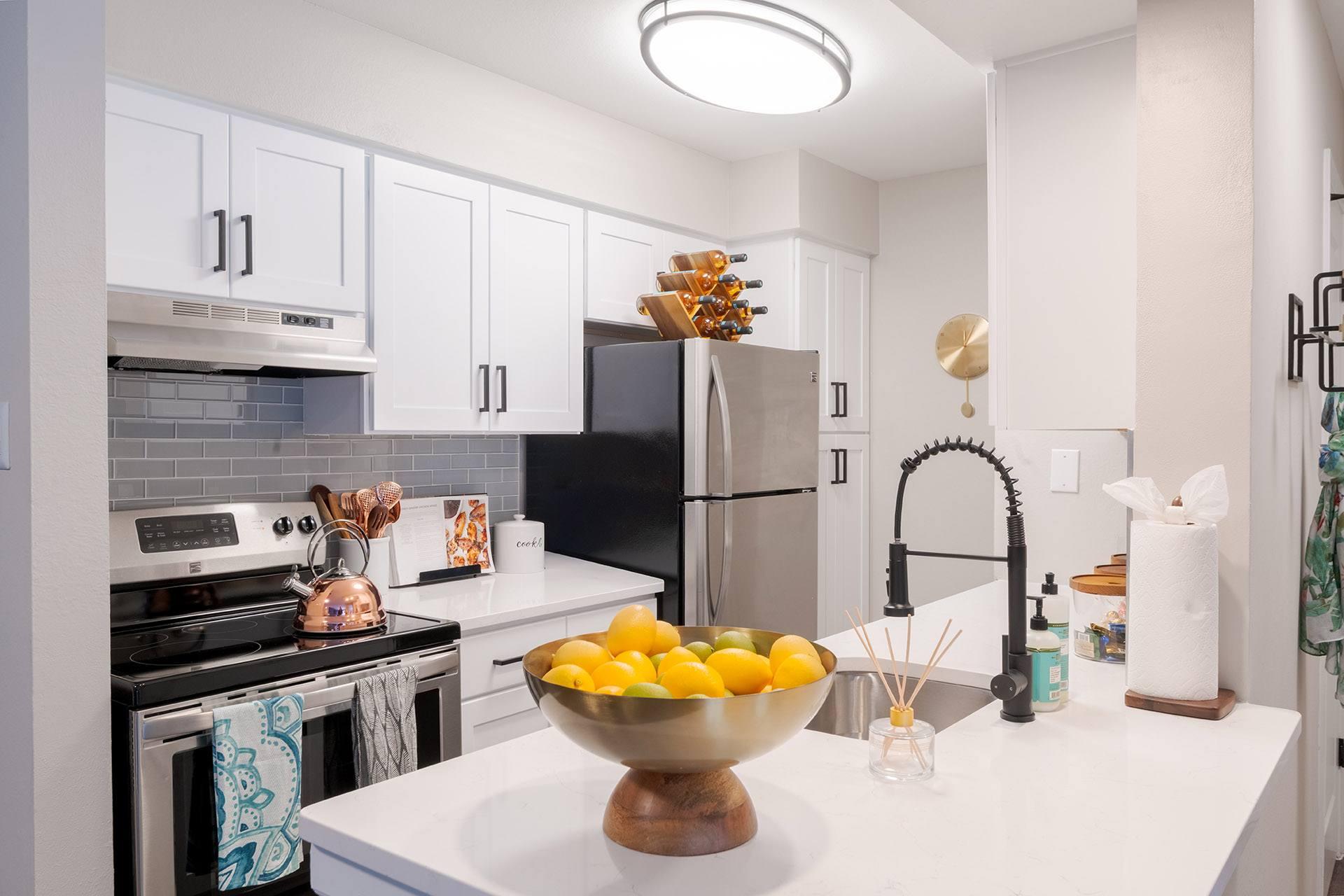 A kitchen with a bowl of lemons on the counter.