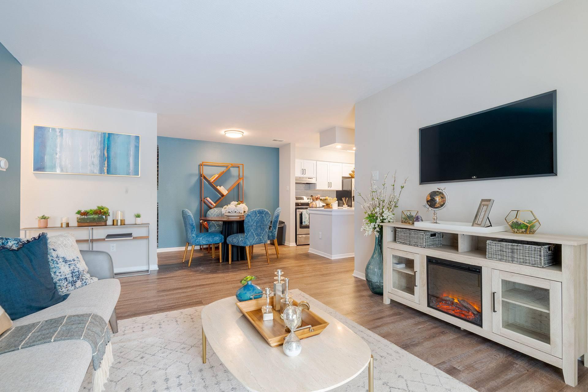 A living room with a grey sofa, a coffee table, a fireplace, and a television.