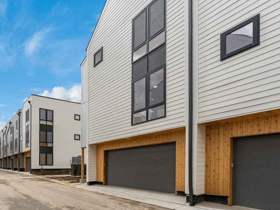 A row of modern houses with wooden garage doors.