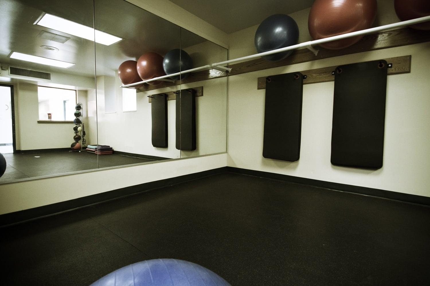 A gym with a blue exercise ball in the foreground.