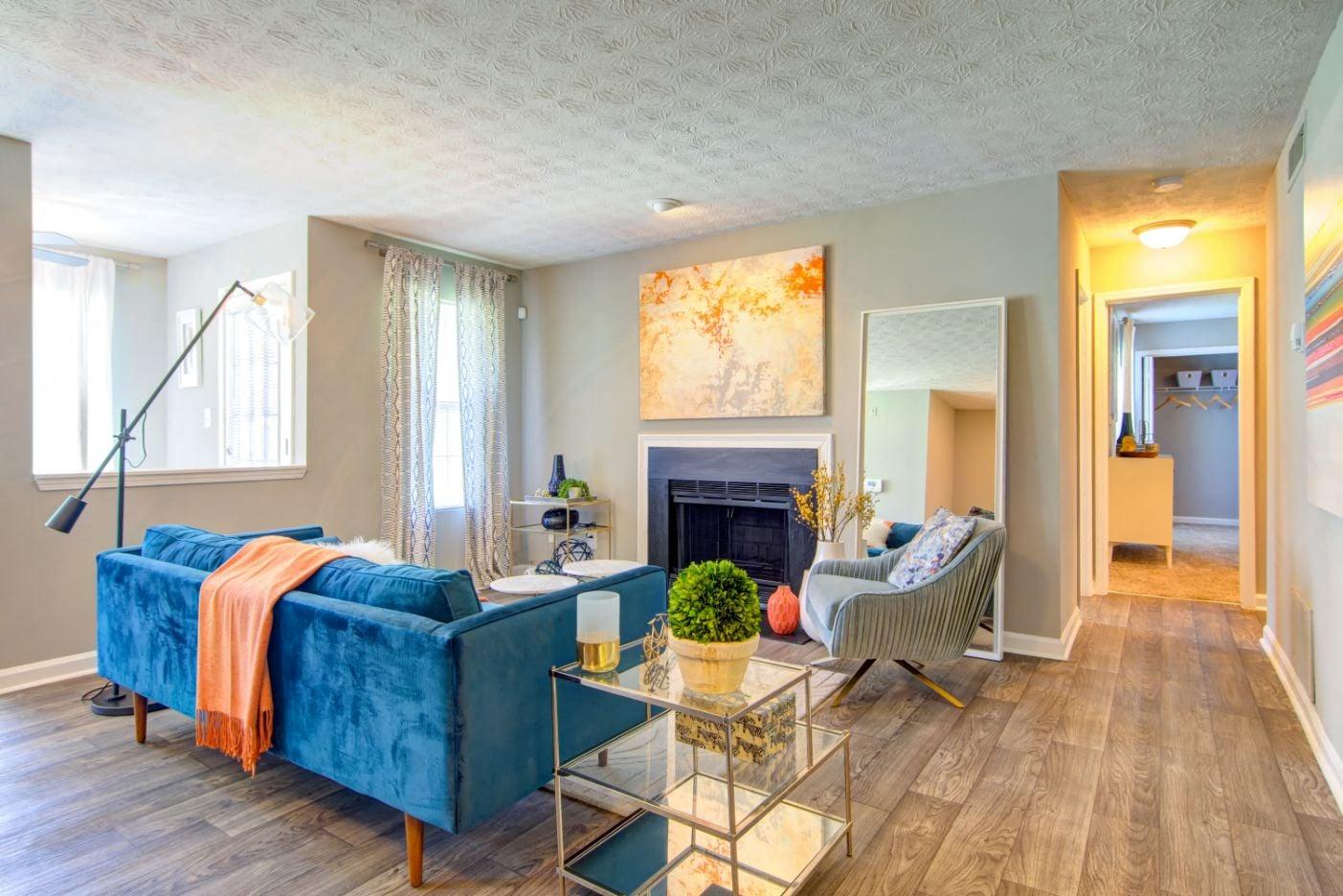 a living room with a blue couch and chair in front of a fireplace