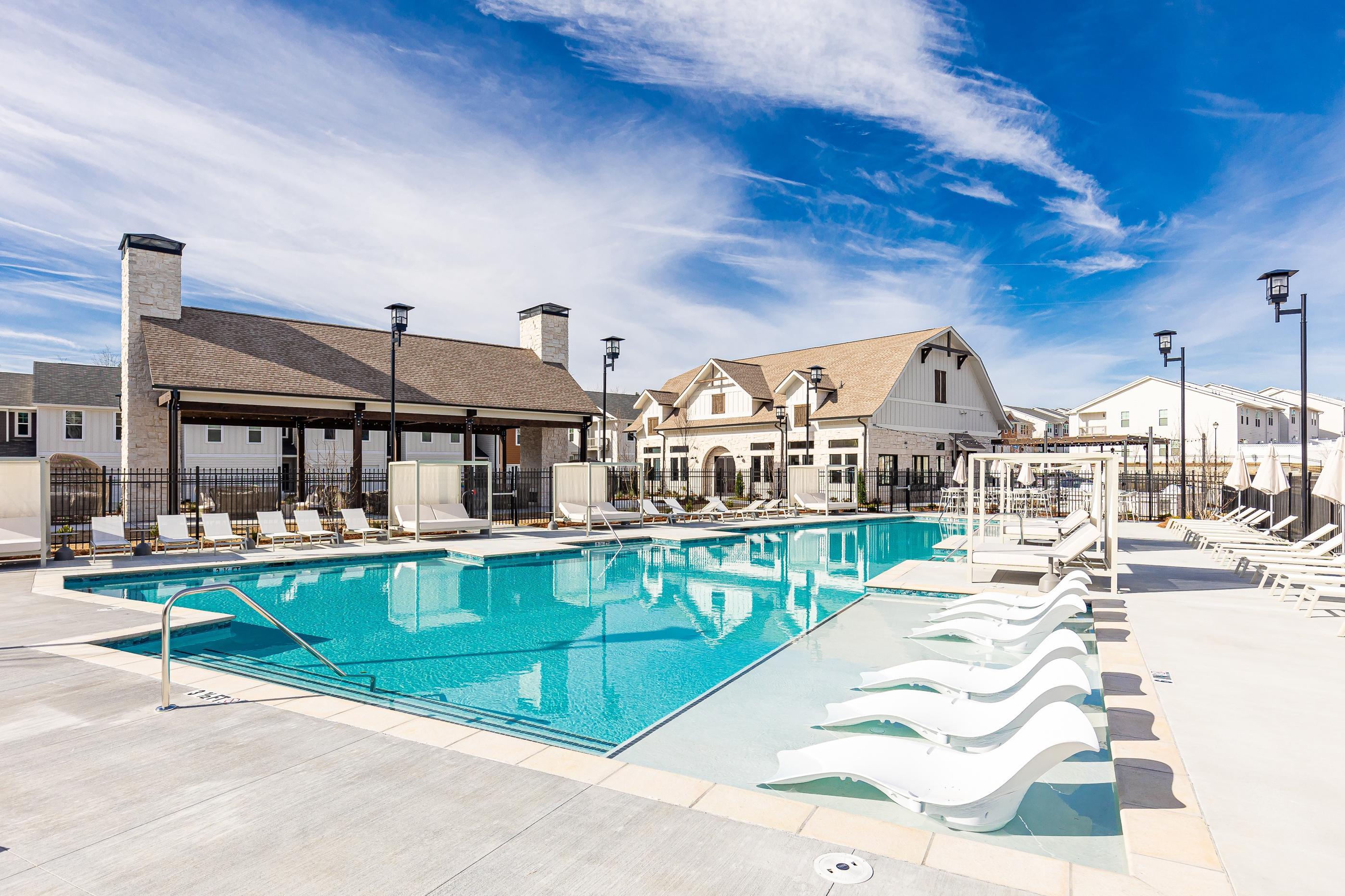 A large swimming pool with a white building in the background.