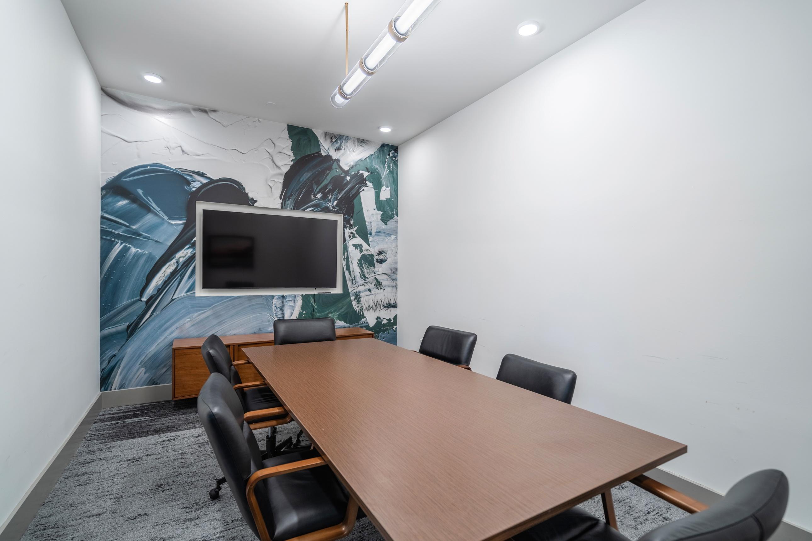 A conference room with a long table and chairs.