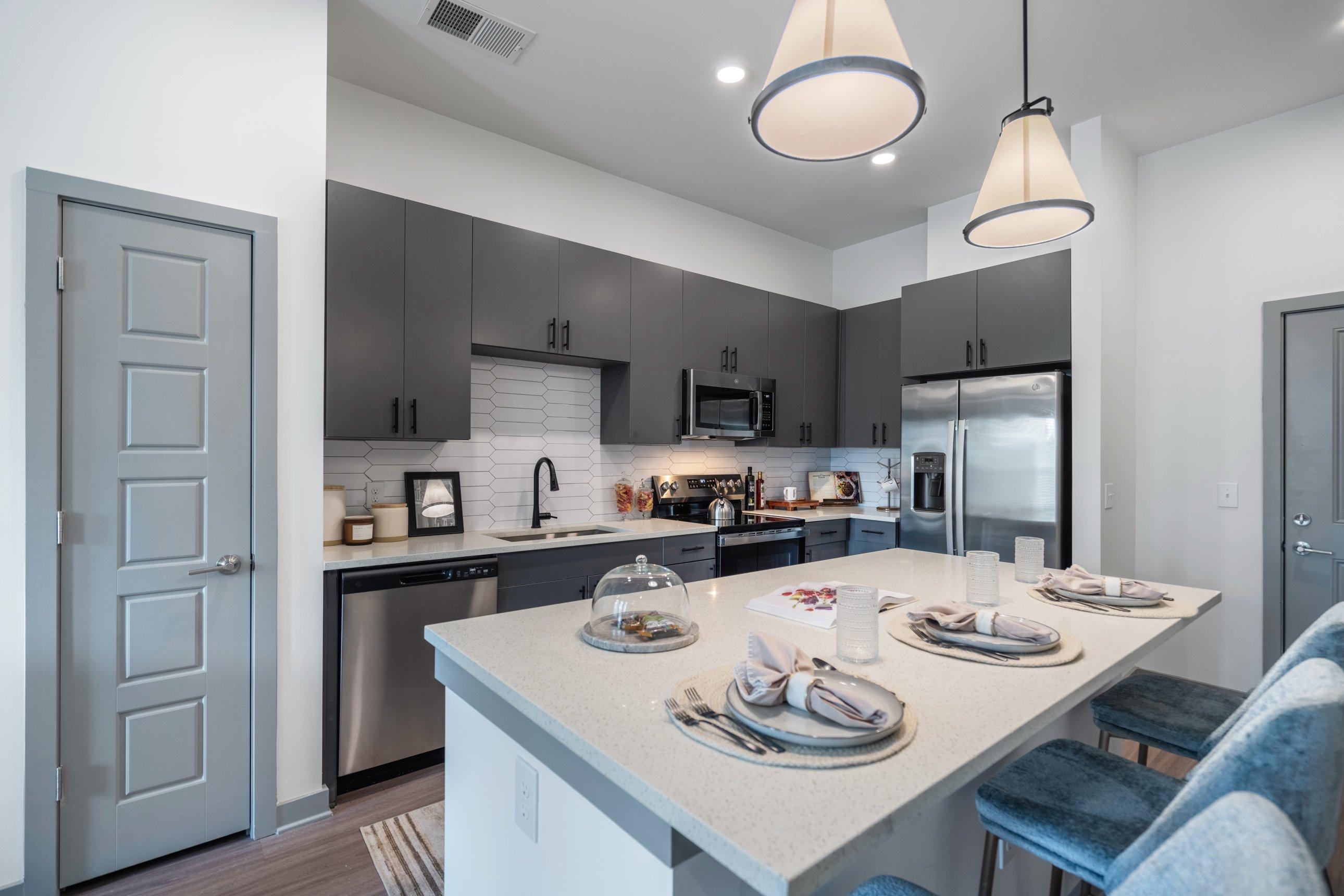 A modern kitchen with a dining table set for two.